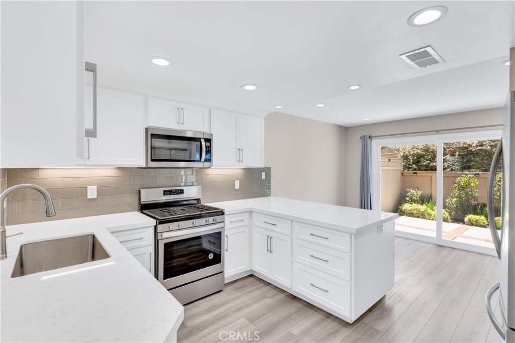 Welcome to this beautifully upgraded MOVE IN ready home! Step into style and sophistication in this stunning, fully upgraded 3-bedroom, 2.5-bathroom condo located in the highly sought-after community of Glenwood Park. Brimming with natural light and designed with luxurious finishes throughout, this home offers the perfect blend of elegance, comfort, and modern convenience. As you enter, you're welcomed by dramatic high ceilings, expansive windows and sliding glass doors that lead to a perfect backyard. A chic, custom-tiled fireplace adds a cozy yet upscale touch, making the living room an inviting space to relax or entertain. The upgraded designer kitchen is a true showstopper—featuring custom soft-close cabinetry, gleaming Quartz countertops, a glass tile backsplash, and sleek stainless steel appliances. Enhanced by LED recessed lighting and under-cabinet illumination, it’s a chef’s dream! Throughout the home, you’ll find wide-plank waterproof wood laminate flooring, combining durability with high-end style. Upstairs, all three bedrooms are generously sized and feature mirrored wardrobe doors, window blinds, and serene natural light. The bathrooms feel like a luxury spa, boasting Quartz countertops, custom tile and stone showers, frameless glass enclosures, and modern cabinetry and fixtures—each detail meticulously chosen for both comfort and visual appeal. Sliding glass doors from both the living and dining area lead to a spacious, private patio with concrete and brick detailing—perfect for al fresco dining, weekend gatherings, or simply soaking in the sunshine. The attached two-car garage adds convenience and additional storage as well as 220v receptacle plug in garage for electric car charging. Located within the lovely and well-maintained community of Glenwood Park, residents enjoy access to resort-style amenities, including a sparkling pool, soothing spa, clubhouse with fitness center, tennis courts and pickleball, scenic trails, parks, and playgrounds—all set among tree-lined streets and tranquil greenbelts. Perfectly situated near shopping, dining, hiking, award-winning schools, and OC’s best beaches, this home truly offers the ultimate Southern California lifestyle. This turnkey beauty is move-in ready and sure to impress.