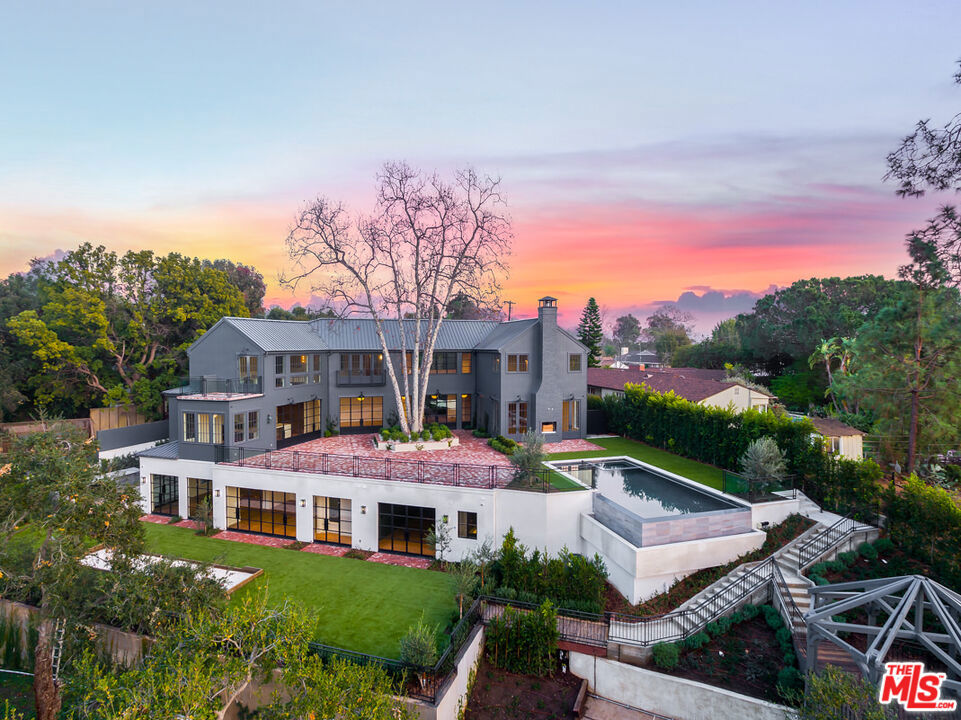 Immerse yourself in the epitome of natural elegance and understated luxury at 665 Walther Way! One of the finest homes on the west side, nestled in a serene tree-lined cul-de-sac in Brentwood. Built and designed by Mosh and Schwab, this meticulously designed estate offers seamless indoor/outdoor entertaining space, family comfort, and privacy. The home boasts 14-foot ceilings, custom iron windows, and wide-plank wooden floors throughout, all bathed in an abundance of natural light. Schwab curated all the cabinetry and woodwork with the most talented local artisans to provide a timeless design. The large chef's kitchen features custom cabinetry, top of the line appliances, a gorgeous marble island and a charming breakfast nook. The kitchen is conveniently connected to both a large family room and a formal dining room with butler's pantry. The main floor interior also features a large bedroom (or office) with en-suite bathroom, a gorgeous living room, library, mud room and garage. Upstairs you will find a primary suite with vaulted ceilings, large master closet, stunning sunset views and a walkout balcony to enjoy the redwoods. Upstairs also features a lofted sitting area and three more charming en-suite bedrooms. Step outside to a beautifully landscaped backyard oasis, where an expansive brick patio, perfect for ultimate entertaining, surrounds a majestic sycamore tree. Take in the panoramic views of the majestic canyon and the Santa Monica Mountains while enjoying the ocean breeze filtering through mature oak and redwood trees, olive trees, lavender and rosemary. Relax by the double-edged infinity pool, which overlooks the canyon below, or unwind in the charming wooden gazebo, perfect for yoga or a good book. The lower level boasts a fully-featured outdoor kitchen, a large flat yard with a wooden play structure, a gym, a media room/theater, glass-enclosed wine room, large laundry room, steam shower bathroom, and two en-suite bedrooms. With impeccable design by LA's DISC Interiors, you will be captivated by the sheer beauty and calming nature of every room. The epitome of Westside living, 665 Walther is minutes away from schools, farmers markets, beaches, and restaurants, yet conveniently located to the rest of Los Angeles.