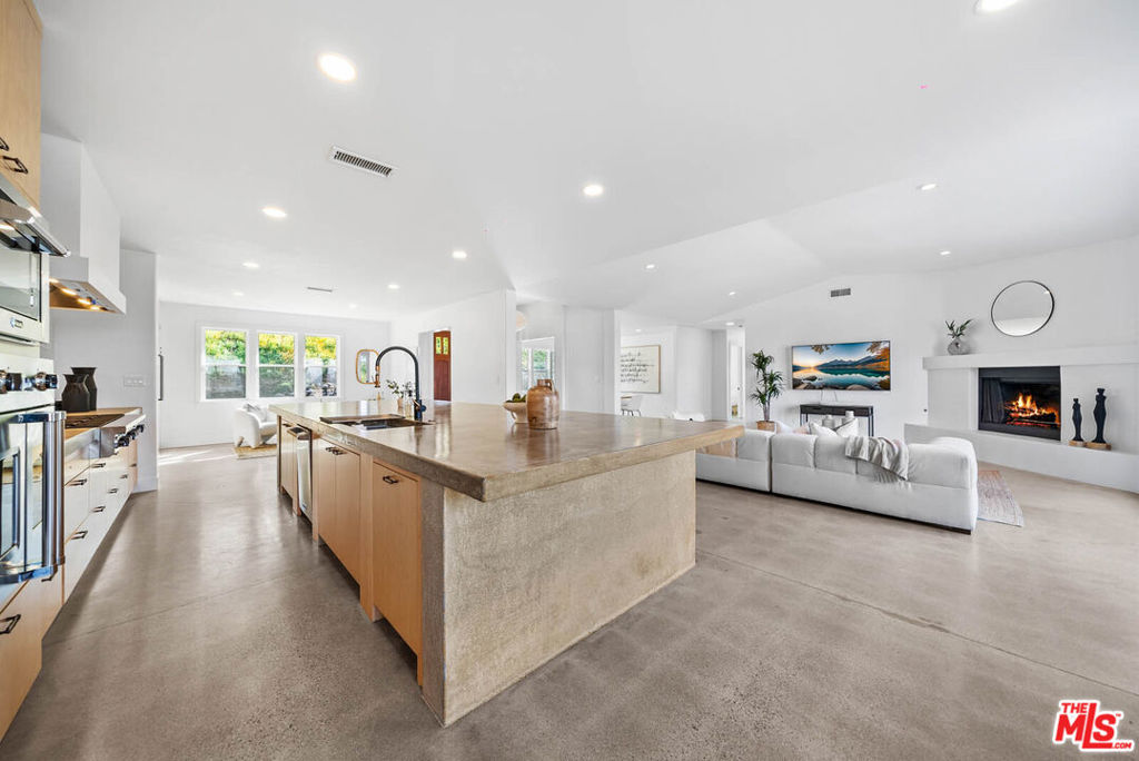 Nestled in the serene hills of Bonsall, and bathed by the famous "Bonsall Breeze" with 180 degree sweeping views. This stunning 4-bed, 3-bath, has just been fully renovated and boasts over 3,100 sqft of San Diego County lifestyle sitting on a private 2.5-acre lot fully gated in rod iron and three entries on to the property. The exquisite gate guides you to a beautifully landscaped entry with a craftsman style stone and stucco entry. Inside, a grand solid wood front door opens to incredible sightlines through French doors leading to the backyard. The open-concept design seamlessly blends the living, dining, and kitchen areas, featuring vaulted ceilings, recessed lighting, and a cozy fireplace. The chef's kitchen presents itself with a massive polished concrete island with seating, a coffee bar and nook, state-of-the-art stainless steel appliances, a Wolf 8-burner gas stovetop and in wall faucet. The primary suite offers vaulted ceilings, patio access, a large walk-in closet with built-ins, and a spa-like ensuite with dual rain showerheads, dual vanities, and a separate W/C. The additional bedrooms are spacious, with ceiling fans and ample storage. The large laundry room includes extra cabinetry, a sink, and folding space. The backyard is an entertainer's paradise with an infinity pool, spa, sauna, outdoor kitchen, stone fireplace with built-in grill, and a pergola-covered seating area. A wraparound patio offers multiple spaces for relaxing and entertaining while enjoying the peaceful surroundings. A spacious 3-car garage completes this luxurious retreat.