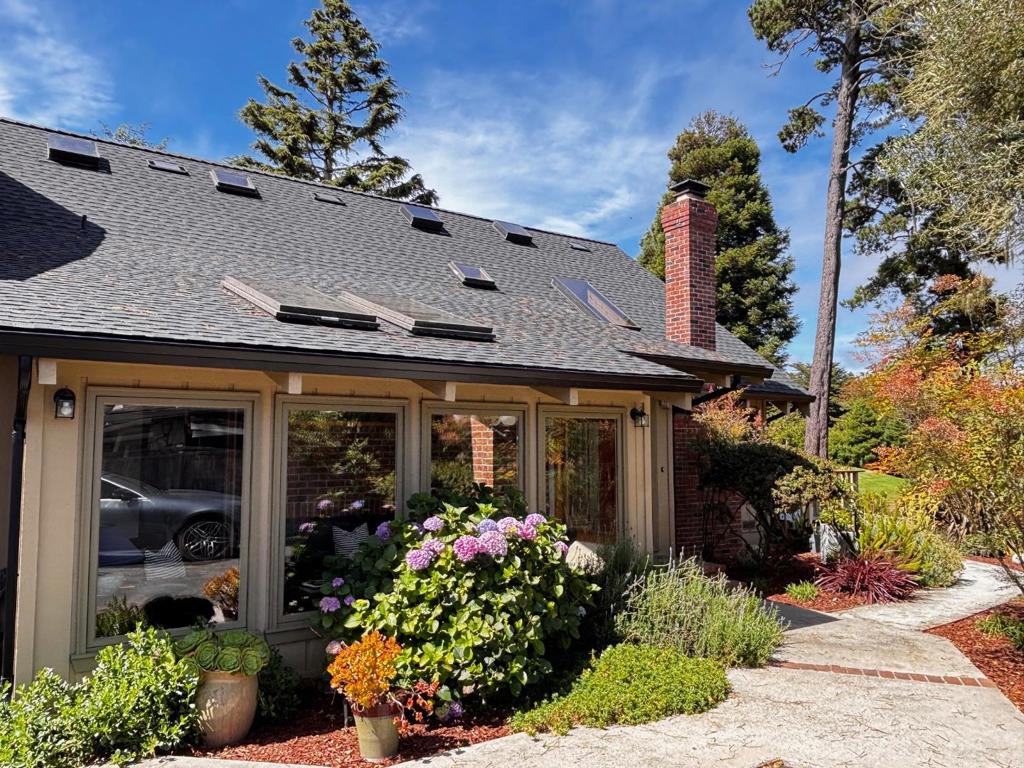 Brand New roof and carpet! Well-built 4-bedroom, 3.5 bath view home just a short stroll to the beach and close to great restaurants, golf, tennis/pickleball, and shopping. Nestled on a protected and private 10,000 plus sq foot lot on a quiet cul de sac with private driveway, this home offers 3,272 sq ft of light-filled living areas with kitchen, living and multiple bedrooms and full baths on the first floor. There's a beautiful sunroom and a cozy living room with Rumford brick fireplace and balconies and decks overlooking the private garden, expansive greenbelt and golf course below. The open kitchen and dining area with vaulted ceilings and skylights is perfect for entertaining or just relaxing while you enjoy the open beam and vaulted ceiling design and open stairwell and landing. There's an oversized 2 car garage with an exterior stairway leading to an upstairs living area over the garage with separate entrance. County says an ADU is ok (Accessory Dwelling Unit) and sellers previously had plans drawn and obtained County approval! The sense of privacy and serenity is truly remarkable for a home this close to the beach and amenities. There's even a separate, sunny fenced backyard accessed from the kitchen with large deck and garden area. Come see and make it your own!