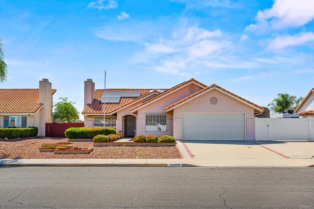 Nestled within the 55+ Sun City neighborhood of Menifee, this single-level residence offers a thoughtfully designed and spacious floor plan. Vaulted ceilings and a skylight flood the interior with natural light. A wall-length custom built-in bookcase wraps around a cozy brick fireplace. The kitchen & breakfast room connects directly to an enclosed patio room that opens onto the backyard—creating a seamless flow for entertaining or quiet relaxation. Two bedrooms and two baths are positioned at opposite ends of the home, offering privacy and separation. There’s also a versatile built-in workspace located just off of an additional den/living space that is ideal for a home office or hobby area. Convenient RV gate access and a covered RV carport make it easy to store or park your toys at home. The attached 2-car garage features built-in cabinets, a workbench, and 2 options for direct access to the house via the laundry room and hobby area. Solar panels (leased) help offset energy costs while aligning with eco-friendly living. The backyard overlooks an open area creek bed and offers access to a walking/biking path which extends for miles. Sun City sits safely within Menifee—a growing Inland Empire city located roughly 15 miles north of Temecula and just north of Murrieta. As part of Southern California, this area is well-connected. To the South you find Temecula’s charming Old Town, wineries, and the outlook of mountain trails. With abundant parks, shopping, and access to wider Southern California’s attractions, it truly is a lifestyle-oriented home. Best of all… this is your chance to gain instant equity! A diamond in the (barely) rough. Bring your vision to life with some paint, flooring and updated landscaping and you’ll surely add value beyond your investment.