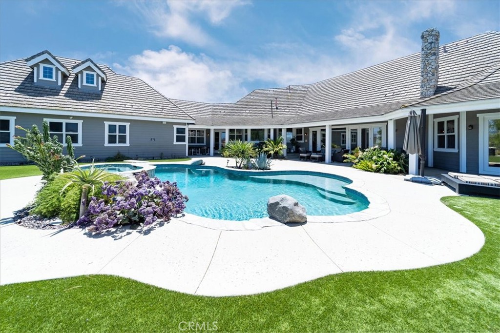 Fly-in convenience meets wine-country luxury with private airstrip access and a 4,800 sq ft hangar. Perched on 7.36 acres of Temecula wine country, this single-story home offers convenience alongside luxurious living. Step inside through a gated entry to a grand foyer with soaring ceilings that opens to a great room featuring a floor-to-ceiling stone fireplace and vaulted wood-beam ceilings. The chef’s kitchen boasts granite countertops, a center island, separate breakfast bar and top-of-the-line stainless steel appliances. Panoramic orchard and mountain views frame the formal dining area. Retreat to the master suite with vaulted ceilings, a private fireplace and dual French doors leading to the landscaped backyard oasis. Enjoy a sparkling pool and spa, dual-sink vanity, jetted jacuzzi tub, large walk-in shower and his-and-hers closets. Three additional bedrooms include two en-suite baths and one versatile room currently used as a home office with its own private entrance. Beyond the home, aviation enthusiasts will love the covered storage adjacent to the hangar and the large, flat event area perfect for RVs, car shows or gatherings. A full-size lighted pickleball court and ample covered storage complete the outdoor amenities. With dramatic “360-degree” views, privacy and unparalleled access to a private runway, this rare Temecula property may never be matched. Schedule your private showing today and experience a lifestyle that combines luxury, recreation and aviation. You will NOT see a listing like this again…