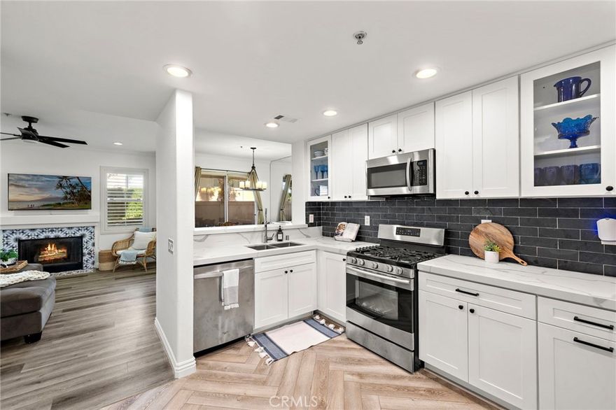 Step into this beautifully upgraded and freshly painted dual primary corner-unit home, nestled in the highly sought-after community of California Court. This charming two-bedroom, two-bathroom single level residence spans 1,365 square feet and offers modern style paired with everyday comfort. As you enter, you'll immediately notice the luxury vinyl flooring and plantation shutters throughout, contributing to the home's inviting ambiance. The kitchen is a true showpiece, boasting a recent renovation with quartz countertops, shaker style cabinets, stainless steel appliances, a chic backsplash, and a dedicated coffee bar. Designed with an open-concept layout, the kitchen effortlessly flows into the light-filled living and dining areas, complete with recessed lighting and a decorative fireplace, creating a warm and welcoming atmosphere. Step outside to your oversized private patio, perfect for entertaining guests or enjoying quiet moments of relaxation. Each bedroom is generously sized with its own private en-suite bathroom. The primary suite features a stunning remodeled bathroom with sleek tile and a walk-in shower, providing a luxurious retreat. The second suite offers ample space for guests or family members, ensuring comfort and privacy for all. Additional features include an attached single car garage with washer and dryer hook ups in unit and plenty of room for storage. Residents of California Court enjoy an array of amenities including a community pool, spa, barbecue area, and the convenience of included parking. Perfectly positioned near shopping, dining, and major freeways, this exceptional home combines modern elegance with a lifestyle of comfort and leisure. Opportunities to own in California Court are rare, don’t miss the chance to make this your sanctuary.