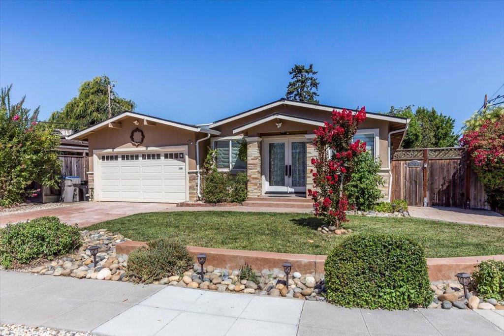 This beautifully updated 4 bedroom, 3 bathroom home features a bright, open floor plan with soaring cathedral ceilings - ideal for both everyday living and effortless entertaining. Thoughtful design details and quality finishes shine throughout, including granite countertops, stainless steel appliances, engineered wood flooring, elegant chandeliers, and timeless wainscoting. The spacious kitchen opens seamlessly to the combined living and dining area, creating a warm, inviting space. Enjoy the flexibility of two primary suites, including a grand primary retreat with cathedral ceilings, a generously sized closet, and a spa-inspired bathroom with dual sinks. Step outside to a nicely landscaped yard with a large stamped-concrete patio and gazebo - perfect for entertaining, dining al fresco, or simply unwinding outdoors. A finished 2-car garage offers ample storage and utility. Ideally located near shopping, schools, and with convenient freeway access, this move-in-ready home is not to be missed!