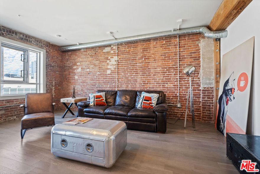 Welcome to Warehouse #1 at Barker Block - Unit 308, a rare corner loft where historic character meets modern design in the heart of the Arts District. This sun-splashed residence features oversized living room windows framing Molino Street and a dramatic floor-to-ceiling glass wall in the bedroom overlooking a serene open courtyard. Originally released in 2014 as the newest phase of the iconic Barker Block community, this loft blends authentic industrial elements original timber beams, exposed red brick walls, and visible duct work with contemporary upgrades designed for today's lifestyle. Highlights include a spa-inspired bath with a deep soaking tub, wide-plank wood floors, energy-efficient dual-pane windows, stainless steel appliances, quartz countertops, and sleek soft-close cabinetry. Additional conveniences include an in-unit washer/dryer and a smart NEST thermostat. Residents enjoy access to Barker Block's resort-style rooftop oasis complete with a sparkling pool, hot tub, cabanas, fitness center, and panoramic views of the DTLA skyline. Step outside and immerse yourself in one of L.A.'s most vibrant creative communities, surrounded by galleries, artisan coffee roasters, and some of the city's best dining destinations. ***Some utilities and 1 parking space included.***