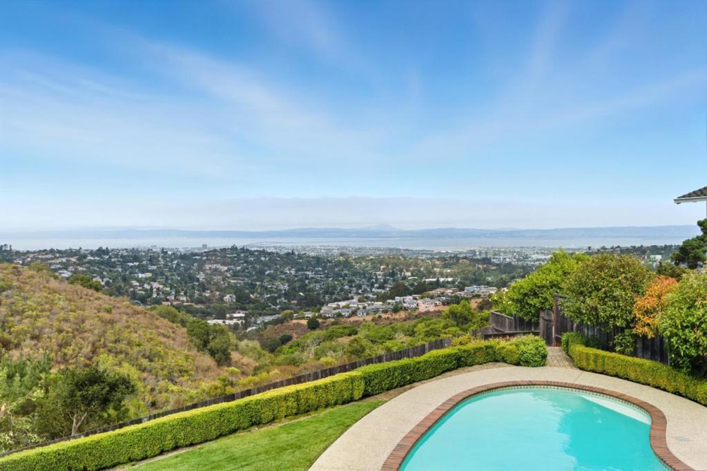 Stunning views in an absolutely pristine home! Perched in Belmonts highly sought-after Hallmark neighborhood, this beautifully updated home is located at the end of a cul-de-sac. With sweeping Bay views from both levels, it offers a stunning backdrop for daily living and entertaining. Light-filled living and dining rooms feature vaulted Shiplap ceilings and a cozy wood-burning fireplace, while the chefs kitchen boasts high-end stainless-steel appliances, an abundance of custom cabinetry, and a large sunny eat-in area. The adjacent family room offers media cabinetry, a gas fireplace, and a wet bar with wine refrigerator, perfect for gatherings. A half bath completes the main level. Upstairs, four spacious bedrooms are thoughtfully arranged on one level, including a fantastic primary suite complete with a vanity, tile stall shower and spacious closet with built-ins. Gleaming hardwood floors, plush carpeting, and crisp paint enhance the homes timeless appeal. Outside, the expansive level lot is designed for year-round enjoyment with a manicured lawn, sparkling pool, multiple patios, a built-in BBQ, TV, and a fire pit - an entertainers dream!