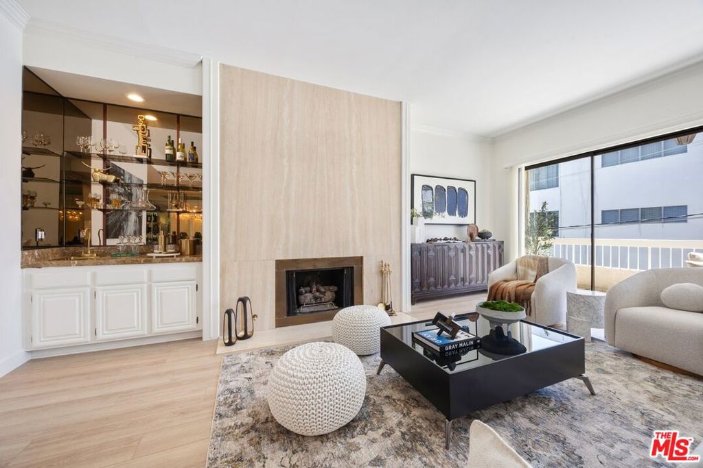 Welcome to prime Beverly Hills living! This beautifully updated 2-bedroom, 2.5-bathroom penthouse condo offers the perfect blend of style, comfort, and unbeatable location. This bright, corner penthouse unit, is drenched in natural light thanks to floor-to-ceiling windows in the spacious living area. Both bedrooms are generously sized with en-suite bathrooms, and the primary suite features an expansive closet. Recent upgrades include new laminate wood flooring, brand new carpet in the bedrooms, and a fresh coat of paint throughout. The centerpiece of the living room is a stunning marble decorative fireplace, adding a touch of elegance and charm along with an expansive private balcony accessible from both the living room and the kitchen. The kitchen is well-equipped with a new stovetop, recessed lighting, double-door refrigerator, dishwasher, pantry cabinets, and a charming breakfast area. A convenient powder room is located off the main living space. Additional features include a dedicated laundry room with washer/dryer hookups, ample storage throughout, and two assigned parking spaces in a secured garage. Situated right near iconic spots like Bristol Farms, Ralphs, the Troubadour, Dan Tana's, and both Melrose Ave and Santa Monica Blvd, this is truly in the heart of it all.