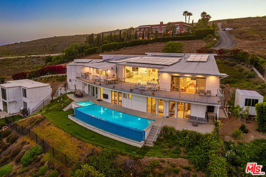 Architectural estate with pool and ocean views in Malibu, masterfully completed in 2019. This stunning 5-bedroom, 5.5-bathroom main residence offers 4,400 sq.ft. of luxurious living space, complemented by a permitted detached guest house boasting an additional 1,200 sq.ft. with 3 bedrooms and 2.5 bathrooms, perfect for hosting family and friends or as an inspiring workspace. Perched to capture breathtaking ocean and hillside views stretching from the Queen's Necklace along Santa Monica Bay to the distant Channel Islands, this home's design and craftsmanship are unmatched. Viking appliances, custom-made cabinetry, quartz countertops, ceramic tiles imported from Spain, and Canadian maple hardwood floors define the sleek and modern interior. German Duravit toilets and seamless finishes further elevate the home's refined style. This property is fully solar-powered, featuring back-up Tesla batteries to ensure uninterrupted power and wifi connectivity, a must in Malibu's dynamic coastal climate. Entertain in style on the expansive 1,300 sq.ft. ocean view deck with an outdoor kitchen BBQ, or unwind by the natural gas-heated infinity pool and spa, complete with a surrounding sundeck and lush lawned backyard. Families will delight in the dedicated children's play area. Ample on-site parking and a 2-car garage with built-in storage ensure convenience for all. Ideally located with easy access to Paradise Cove Beach, Point Dume Market, and shops, and nearby top-rated schools, this architectural gem blends privacy, luxury, and functionality in one of Malibu's most coveted locations. Can be leased unfurnished for $24k per mo. or $27,000 per month furnished.
