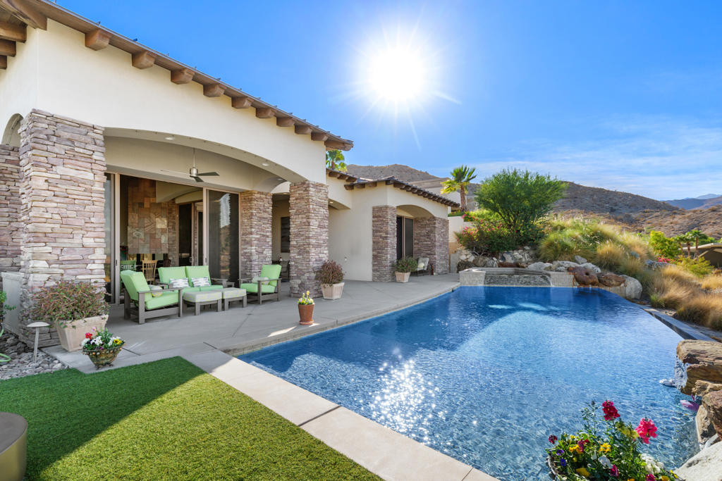 One of the best views in the entire Coachella Valley! Perched on an elevated corner lot within Rancho Mirage's exclusive Mirada Estates, this architecturally distinct residence captures the essence of refined desert living. With expansive walls of glass, the home showcases spectacular mountain and city light views from every room, merging indoor and outdoor spaces in perfect harmony. Privacy is paramount in this 3,964 sq. ft. retreat, which features three luxurious en-suite bedrooms, including a primary suite with steam shower and heated floor, and a private-entry casita. A Murphy bed in the den/office increases the sleeping capacity to 8+. Elegant design elements, from quartzite stone finishes to the custom built-in storage, underscore the meticulous craftsmanship throughout. At the heart of the home, a recently remodeled gourmet kitchen with Wolf appliances, Subzero refrigeration, and custom quartzite counters enhances the home's unique architectural flair. The outdoor spaces, featuring an infinity-edge saltwater pool, cooling misters lining the patios to cool down hot summer days, Burning Bush fire pit, and expansive patio areas, provide an ideal setting for both relaxation and entertaining. The home is equipped with a wholly owned 52 panel rooftop solar system and Tesla Power Walls, and a whole-house music system, marrying high-end technology with environmental sustainability. Residents enjoy exclusive access to the Ritz-Carlton's Mirada Preferred Access Program, which includes discounts on dining, spa services, and fitness facilities, as well as special room rates and privileged access to resort amenities. This remarkable property is an ideal choice for those seeking an elevated lifestyle with privacy, unparalleled views, and access to world-class amenities.