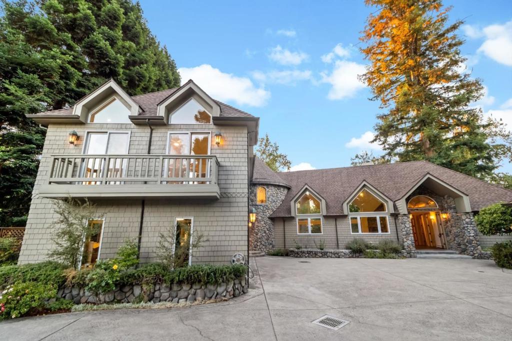 Tucked in the exclusive Edgewood Park neighborhood, this stunning estate greets you with a long private driveway, generous parking, and an impressive facade of high-peaked roofs, a three-car garage, and a welcoming formal entry. A charming detached cottage with its own backyard and private entrance offers exceptional versatility. Inside the main house, a grand office, soaring chapel-like ceiling living room, and a light-filled great room with oak floors and an open kitchen set the stage for elegant living. Walls of windows frame the lush backyard, while the classic staircase adds timeless character. The main level also features two oversized bedrooms, 1.5 baths, and a convenient laundry room that leads into garages. Upstairs, the primary suite boasts a fireplace, serene views, and a sprawling deck. A fourth bedroom large enough to serve as a family room completes the home. Minutes from downtown, 101, and 280, this is a rare blend of privacy, beauty, and convenience.