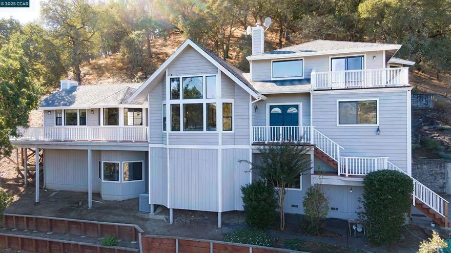 Welcome to 59A Saddle Road in Walnut Creek’s Castle Hill neighborhood. This 5-bedroom 3.5-bath custom home offers nearly 3,200 sq ft of light-filled living with panoramic East Bay views and Tahoe cabin charm.  The Great Room features soaring cathedral-style vaulted ceilings with exposed wood beams and oversized picture windows that frame serene tree-top views. A second living room with its own wood-burning fireplace provides another inviting space to gather, relax or entertain.  The kitchen features stone counters, a large island, skylight and built-in appliances with access to a wraparound mezzanine deck that captures expansive valley views.  A lower-level suite includes its own bath and laundry ideal for guests, in-laws or multi-gen living. The primary suite offers a private deck, a jetted tub and a walk-in closet.  Multiple view decks and landscaped gardens complete this tranquil retreat minutes to downtown Alamo or Walnut Creek, top Acalanes schools and scenic hiking and biking trails.