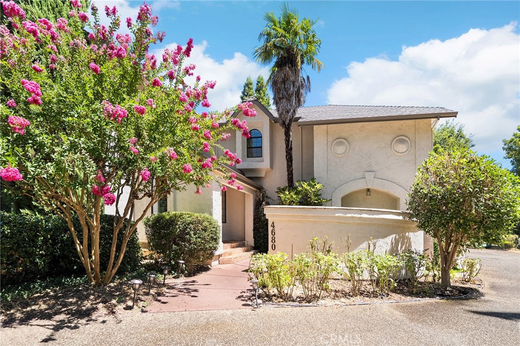 Welcome to this stunning Mediterranean estate located on an expansive corner lot in the sought-after Quail Run neighborhood in North Chico. Set on nearly an acre, this impressive home offers over 3,000 sq. ft. of living space, 4 bedrooms, 3.5 bathrooms, and a thoughtfully designed layout featuring two primary suites and multiple living areas—perfect for multigenerational living or hosting guests in style. Step through double doors into a grand formal living room with soaring cathedral ceilings, an elegant floor-to-ceiling fireplace, and a wet bar that makes entertaining effortless. Just off the living room is a formal dining space, a spacious kitchen featuring granite countertops, a center island with breakfast bar seating, and ample cabinetry. It opens to the cozy family room where a freestanding stove adds warmth and charm, and glass doors lead out to the inviting back porch. The upstairs primary suite is a luxurious retreat with a private terrace, huge walk-in closet and en-suite bathroom featuring a soaking tub, walk-in shower, and dual-sink vanity. Down the hall are two generously sized guest bedrooms, both with walk-in closets, and a shared bathroom. At the end of the hall, you'll find a second primary suite with its own en-suite bathroom—ideal for extended family or visitors. The outdoor space is just as exceptional. Enjoy the park-like front yard, a fully fenced backyard with mature landscaping, a spacious deck, garden beds, and don't miss the charming courtyard with a built-in fireplace. Fruit trees, grapevines, and berry bushes can be found on the property— the owner even made their own wine! Tucked within a neighborhood known for its beautiful homes and festive holiday spirit, this estate offers the perfect blend of space, comfort, and charm in one of Chico’s most beloved communities. Don’t miss this rare opportunity to own a truly special property.