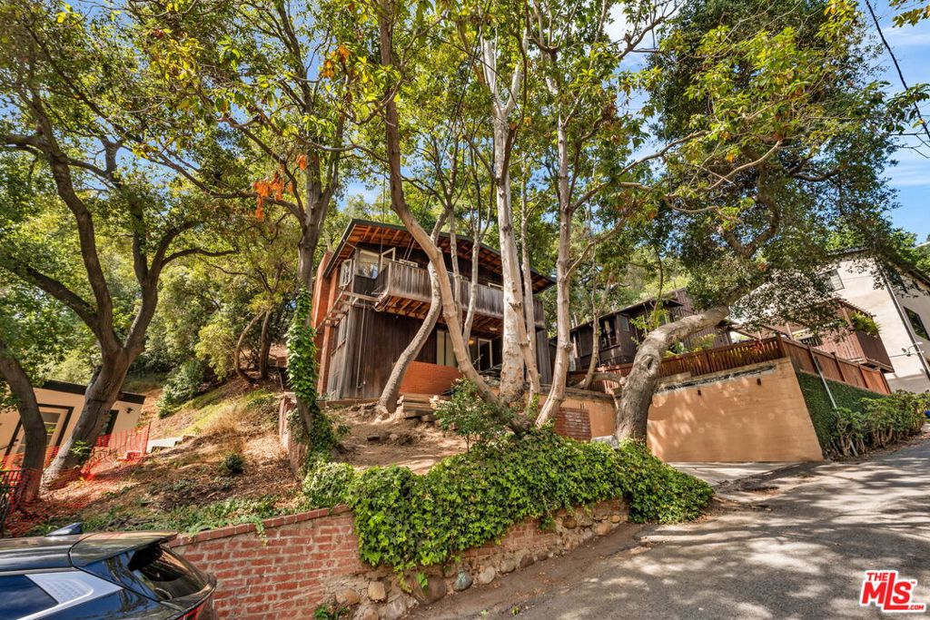 Available to market for the first time in 57 years, the Wertheimer House is a rare opportunity for architecture enthusiasts to preserve and restore an untouched piece of Los Angeles history. Documented by influential mid-century photographer Julius Shulman in 1962, this Beverly Glen canyon retreat articulates the major ideas of Southern California modernism: simplicity, economy, integrity and harmony with the natural environment. Built in 1959 by architect Lester Wertheimer, FAIA, as his own family residence and offered in its original condition, the home features two bedrooms that open onto a shared balcony, two bathrooms, an office (or possible third bedroom), as well as a private backyard patio nestled into the hillside and shaded by a canopy of mature oak and eucalyptus trees. Mid-century details include original custom built-ins and fixtures, three fireplaces, floor-to-ceiling glass doors, dynamic integration with nature, and an efficient two-story layout for harmonious living. Other amenities include off-street parking for two cars and easy access to UCLA, the Getty Center and Skirball Cultural Center, the Glen Centre as well as all the dining, shopping and services of Beverly Hills, Westwood, Ventura Boulevard and Brentwood. Nearby hiking trails and canyon roads connect you to the natural beauty of Stone Canyon Reservoir and the Santa Monica Mountains. The house is zoned for the coveted Roscomare Road Elementary School. With only two owners in its lifetime, the Wertheimer House seeks a new generation of stewardship to guide it into its next chapter.