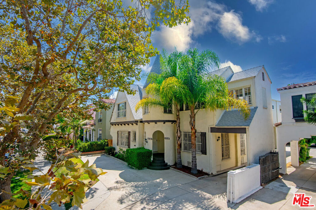 Charming 1920s townhouse-style duplex with hardwood floors, floor-to-ceiling windows providing lots of natural light, in-unit washer/dryer, & rear garage (2 car garage + 1 driveway spot). Downstairs offers a spacious living room, large dining room, & oversized kitchen with full appliance package, breakfast area & a half bath. Upstairs features 3 bedrooms + 2 bathrooms. The front bedroom offers 2 large walk-in closets (one could be an office), a second BD with ample closet space & bathroom in-between the 2. The primary bedroom boasts double closets, built-ins for storage, & an en-suite BA providing dual vanity, tub/shower, + linen closet. Grassy courtyard, balcony w a view, & unbeatable Beverly Grove location complete this rare offering.