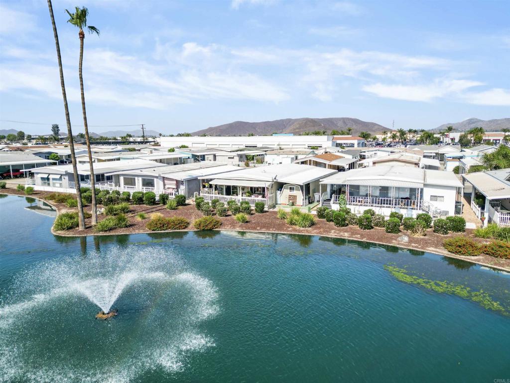 The Lakes of Hemet West is a 55+ community offering stunning water views in a beautiful, peaceful setting. Enjoy resort-style living with access to a private 9-hole golf course and a wide range of amenities. Welcome to this charming manufactured home, ideally located directly in front of the lake with a tranquil water fountain. A grapevine-wrapped patio provides serene lake views—perfect for sipping morning coffee or relaxing in the evening while watching ducks, birds, and other wildlife. This turnkey, open-concept home features two spacious bedrooms and two full bathrooms. The layout includes a dining area, family room, and living room, along with a large kitchen equipped with stainless steel appliances and butcher block countertops. Enjoy the lake view through large windows, and appreciate the matching laminate flooring throughout, with tile in the kitchen and covered patio. Outdoor features include a two-car carport, a large shed, covered storage space, private fencing, a driveway, and a patio. Community amenities include safe, parkway-free walking paths and an active lifestyle designed for adults 55 and older. The community is pet-friendly with its own enclosed dog park. Residents enjoy pickleball, horseshoes, smart shuffleboard, and golf putting greens, along with a full calendar of community events. All appliances come with a one-year warranty, including the water heater, air conditioner, and heater.