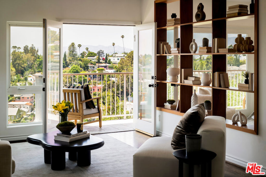 Welcome to this beautiful, 4-bedroom view property in the best neighborhood of Silver Lake. Located just above Silver Lake Boulevard, on a quiet street with breathtaking views of the Hollywood Sign, Griffith Park, and the Pacific Ocean, this retreat combines timeless charm with city convenience, just steps from Silver Lake's best shopping and dining. Breathtaking city and canyon views steal the show in this stylish home, where rich wood floors and glass-paned doors let natural light soak in from sunrise to sunset. A custom bookshelf adds character while keeping the flow open between the living and dining areas. Host dinners in the formal dining room or take the party outside to the balcony. A brand-new HVAC system keeps things comfy year-round, and the Sonos system allows for seamless whole-home audio. Downstairs, the spacious family room anchors the bedroom level, framed by oversized windows that flood the space with natural light. The primary suite is a true retreat, featuring a spa-like bath with a floating dual-sink vanity, glass-enclosed shower, and soaking tub. Secondary baths are equally stylish with sleek, modern finishes. Although this home feels completely private and secluded, you are just moments from popular spots like Alimento, LAMILL Coffee, L & E Oyster, and the Silver Lake Reservoir.