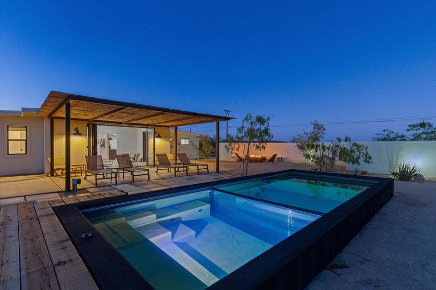 Nestled on a pristine 3-acre parcel in the heart of Joshua Tree, 4610 Sunkist Road is a one-of-a-kind architectural retreat blending refined Mediterranean influences with modern desert minimalism. This 3-bedroom, 1-bathroom home spans 1,568 sq ft and has been meticulously reimagined with a design sensibility rarely found in the high desert. Currently utilized as a top-performing, meticulously maintained Airbnb.Design-forward details include smooth plaster walls, polished concrete floors, handcrafted tiles, and expansive folding glass doors that dissolve the boundary between indoors and out. A luminous open kitchen, two distinct living areas, and curated finishes throughout create a space as functional as it is striking.Step outside to a heated Modpool/spa, sculptural fire feature, shaded lounge areas, and panoramic views framed by olive trees and southern mountains. With 32 owned solar panels, EV charging, and a fully fenced footprint, this ultra-private, turnkey haven is just 8 minutes from the park--perfect for discerning buyers seeking a unique retreat and great investment opportunity.