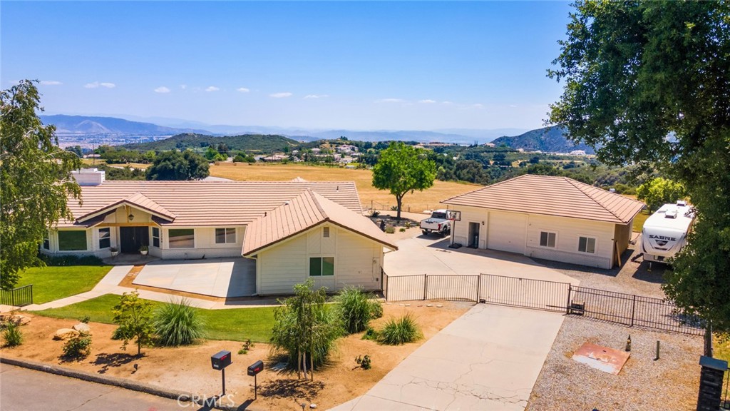 This home is the most exciting listing on the market!! All boxes are checked off: Location, incredible views, layout, style, upgrades, storage, large 1200 sf shop, RV parking, hook-ups and more. Everything about the upgrades in this home have been well planned out and executed down to the last details. The layout is open with comfortable living spaces and large windows for enjoying the spectacular views. The living room enjoys a new contemporary fireplace with remote control thermostat and color changing features. The kitchen boasts a huge island with quartz waterfall, stainless steel appliances, upgraded fixtures and that terrific view. This home has laminate flooring throughout, tile in the primary bath, new interior doors, barn doors, all new cabinetry and bathroom remodels. The primary suite is spacious with a walk-in closet and a gorgeous bath and did I mention the VIEW! The home features designer touches throughout with splashes of color, built-ins and contemporary lighting and fixtures. The 3 car attached garage is finished with new raised cabinetry and tile flooring. The shop is 1200 square feet with an office and a bath. The floors are epoxied, drive thru roll-up doors, and off the floor cabinets. The landscaping , the patio cover, the windows, the tankless hot water heater, the whole house fan are all newer. Move in ready and still some undeveloped land behind the shop for personalizing: gardening, build an ADU, many possibilities. No need to build your dream home, it's waiting for you right here.