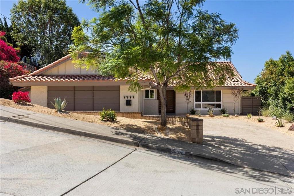 Modern Spanish-style 4 bed, 2 bath home perched on a hillside in La Mesa with sweeping views from inside and from the expansive wraparound side deck. Situated on a 10,000+ sq ft lot, this home offers a spacious backyard and multiple outdoor areas—perfect for entertaining or relaxing. Inside, the semi-open layout features a formal living room plus a separate kitchen/dining area that seamlessly flows to the backyard. The chef’s kitchen is a showstopper with oak cabinets, quartz countertops with waterfall edges, a counter-to-ceiling tile backsplash, and a full suite of stainless-steel appliances including a high-end Forno range. The spacious primary suite is a true retreat, featuring an oversized spa-inspired shower, while three additional large bedrooms offer comfort and flexibility. Recent updates include a new heater/AC and updated plumbing. A generous driveway offers room for a smaller RV, boat, or toys, and there’s a storage room off the back of the garage. With its blend of modern Spanish charm, thoughtful upgrades, and stunning hillside views, this La Mesa gem is the perfect place to call home.