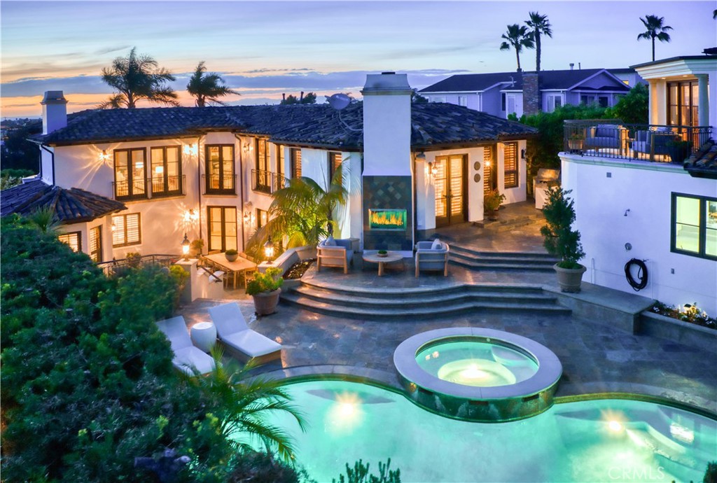 Welcome to 212 John Street, a coastal retreat on one of Manhattan Beach’s most coveted streets. Built custom for the current owner, it possesses mesmerizing ocean views, resort-style outdoor living and meticulously crafted interiors. Just moments from Downtown Manhattan Beach, this estate offers top-tier shopping, dining and entertainment. It is also located near award-winning schools, making it perfect for families seeking premier education. Step through grand double doors into a striking formal entryway. Off the entryway, a junior suite features hardwood floors, dual closets and an elegantly designed ensuite bathroom, with French doors open to a front-facing terrace. The primary suite is a luxurious sanctuary, filled with natural light and French doors leading to another ocean view terrace. The spa-inspired ensuite includes a soaking tub, dual vanities, a separate makeup vanity, private water closet and a large dual-head shower. The first level also features two guest bedrooms with ensuite bathrooms, a secondary entertaining room with a fireplace and pool table, and a spacious bar area. Double French doors flood the space with natural light and lead to the retreat like backyard. A full bath, spacious laundry room with storage and dual washer/dryer capacity, and a rear staircase enhance functionality. Designed to maximize panoramic ocean views and streaming sunlight, the upper level features an open-concept layout with hardwood floors and vaulted wood beam ceilings. The formal living room includes a wet bar, wine fridge, fireplace, and French doors to a terrace with ocean vistas. The formal dining area, seats up to twelve and connects to a butler’s pantry and the gourmet kitchen. A separate landing is ideal for a grand piano, while an elegant powder room is nearby. The kitchen boasts stone countertops, high-end stainless appliances, a Viking stove, and a large center island with bar seating. Adjacent is a cozy family room and breakfast nook for casual meals. A rear door leads to the backyard’s BBQ station and bar. The lowest level offers a media room, a large wine cellar and an additional guest bedroom with bath. Outside, the freshly painted exterior complements a tiered oasis designed for outdoor living. The lower tier has a spacious patio, while the upper tier features a pool, sundeck, outdoor fireplace, and BBQ bar. A separate ocean view guesthouse offers a private refuge, office, or in-law suite. A three-car garage provides ample parking and storage.