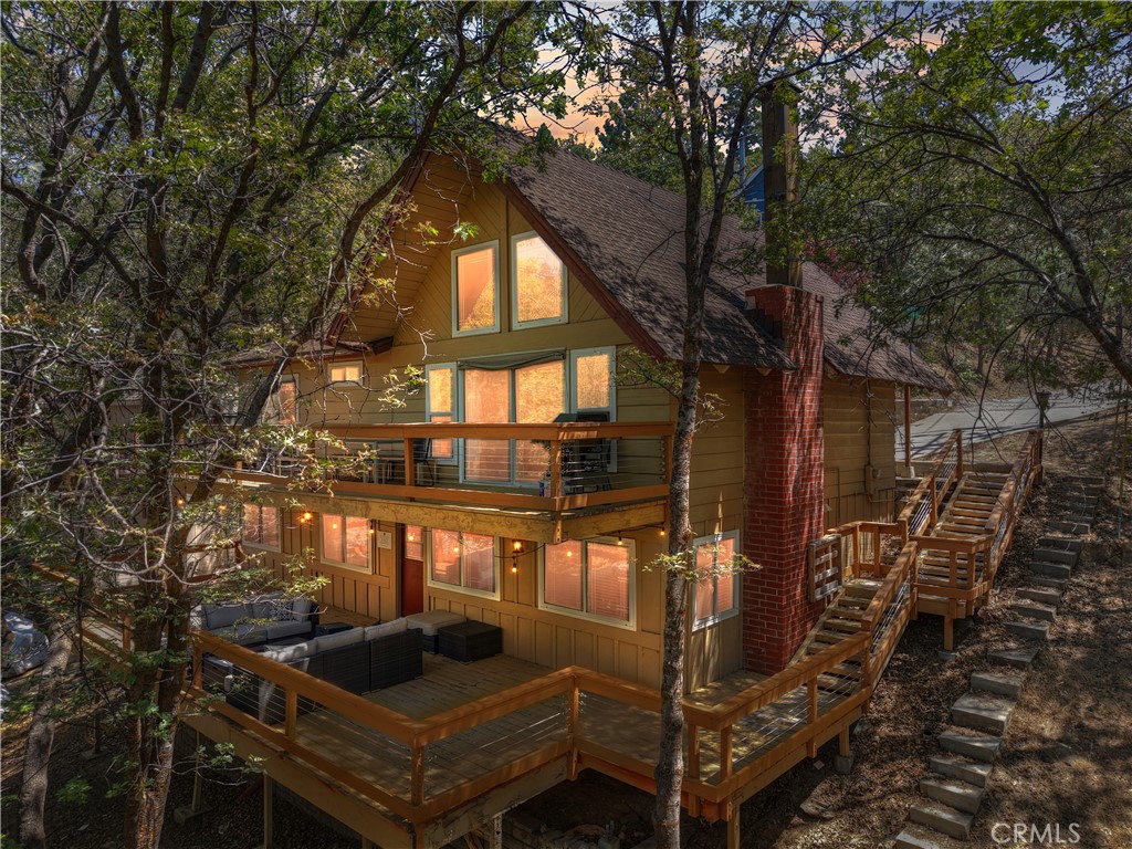 Welcome to Northstar Cabin! Once you step inside this lovingly updated getaway, you will feel your worries melt away. Super convenient location & access with parking right in front, level entry & straight into your main level. It doesn't get any easier than this! Warm wood cabinetry in the kitchen along with stainless appliances & updated fixtures. Cozy dining area & breakfast bar are just adjacent & flow straight into your living space. Vaulted ceilings & a wall of glass overlooking the quiet & peaceful forest surroundings. Beautiful LVP flooring throughout & charming brick fireplace in the living area for those chilly winter evenings. The main floor also has not only one but two bedrooms! The main level bath is stunning with a hammered copper bathtub & separate shower. Downstairs your will find a nice family room & wet bar with access out onto an oversized lower deck. This level also has two additional bedrooms and another full bathroom! The two decks are extra large & offer amazing outdoor space for entertaining and enjoying the outdoors. If you are looking for some income this property is also an active & successful STR. Located on a maintained road & just a quick hop to Tavern Bay beach club & minutes to Blue Jay or Lake Arrowhead Village. Lake Rights included! A must see property that checks off all the boxes.