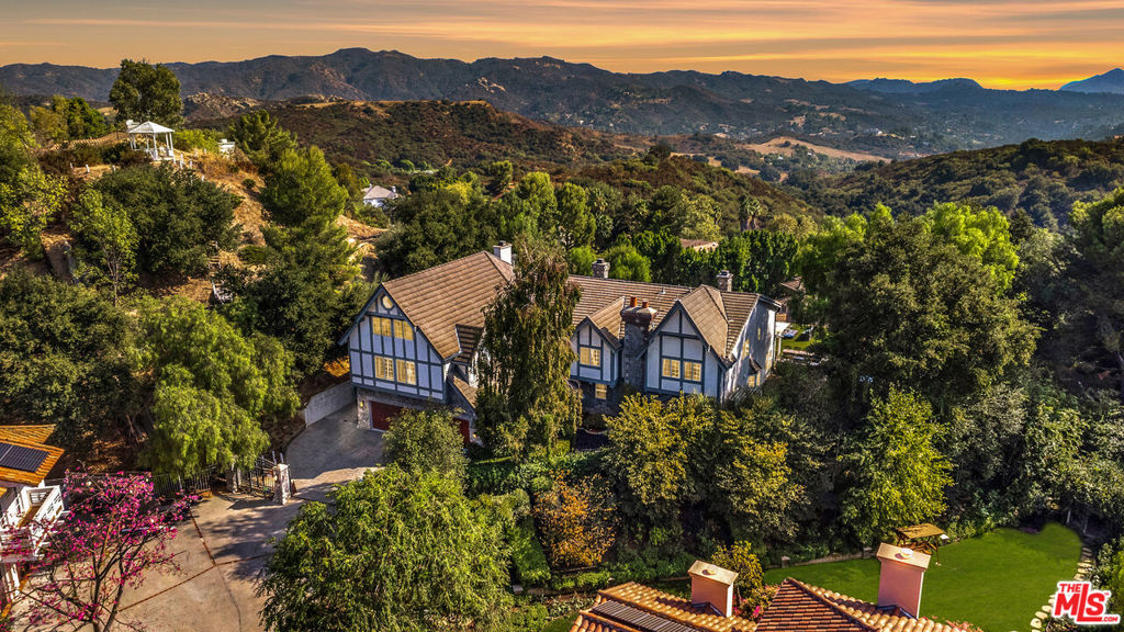 Welcome to Versailles Topanga, a stunning storybook jewel offering panoramic canyon and mountain views, with even distant glimpses of Catalina Island. Nestled on the largest lot at the end of a cul-de-sac, this home ensures complete and gated privacy. Designed and executed in period-authentic 18th Century French Rococo, this masterpiece features custom panels throughout the house designed by Rococo artists and hand-gilded in 23.75 karat gold-leaf, using techniques and materials true to the Rococo Era. Custom-commissioned artwork from the period is embedded throughout the home, adding to its historical charm. The wrought iron balusters, designed and gilded onsite, are modeled after those in the French Embassy, adding a touch of regal elegance. The lower level boasts custom marble medallions, double inlaid Onyx floors, and commercial-grade large format Crema Marfil (Spain) Marble and Marble Baseboard. The magnificent living room boasts soaring, high ceilings in luxurious, walls of floor to ceiling glass and windows framed with Onyx marble casings and Greek Thasos Marble Trim, creating a grand and luxurious ambiance. The open floorplan concept offers a panoramic view of the interior living areas from the grand entry foyer to the opulent living room, the royal formal dining designed with custom built furniture, to the casual family room with romantic fireplace, opening up to a dream granite kitchen with island, new double subzero, two ovens, two stove cooktops, garden window and more panoramic views! There is a large guest bedroom suite on the main level, powder room and laundry room. The elegant wrought iron gold-leaf staircase leads to the upper level, all bedrooms feature double 1" maple borders manufactured in-house around real oak flooring, with custom archways designed to highlight your art collection. The luxurious primary retreat, sitting room and office showcase intricate wooden inlaid floors with borders and Pakistani Red Onyx Marble Baseboard. The primary spa-like bathroom is a haven of relaxation, with book-matched honey onyx up the spa tub, marble borders and inlays made in-house, a steam shower, jet tub, the huge primary suite offers a sitting room, panoramic views, a huge deck, and two large walk-in custom closets. This home also includes a huge home theater, art and music studio, one thousand bottle, temperature-controlled custom wine cellar. You will be blown away by the unobstructed views from almost every room. Extra-large and flat back yard with entertaining pool and spa, a huge built-in BBQ, and manicured lawns with a gazebo make this an entertainer's paradise. No detail was spared in the design of this home. Unique and totally magical, Versailles Topanga is a masterpiece like no other. Nothing else compares!