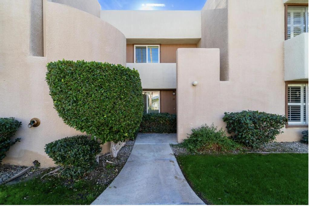 Your ideal Palm Springs getaway or primary residence awaits! Centrally located close to shopping, restaurants and museums, this charming 2 level home is perfectly laid out with your entertaining space and powder room opening to a lovely private courtyard on one level, while the bedrooms and full bath are tucked privately upstairs. There you can take in beautiful Mt San Jacinto views on your balcony. Covered parking is conveniently located just off your back patio. Plus you're just steps to the huge beautiful pool. Move right in and enjoy the ease of desert living, as the home is sold tastefully furnished. The HVAC system was replaced in 2023 along with updated engineered wood flooring, kitchen, bathrooms and plantation shutters added to all windows. This home is situated on a corporate land lease owned by the City of Hope (vs tribal land), which has been extended through 2077, ensuring long-term security. Welcome home!