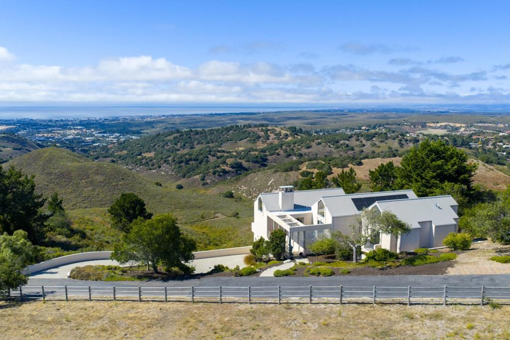 Contemporary elegance with breathtaking Monterey Bay views. Perched atop the serene and lush setting of Saddle Road, this contemporary modern masterpiece embodies a refined architectural vision defined by elegant proportions, clean lines, and meticulous attention to detail. Soaring ceilings and strategically placed light tunnels flood the home in natural light, creating a luminous and uplifting ambiance. The open-concept floor plan flows with grace, intentionally designed to guide your gaze toward the sweeping panoramic views of rolling oak-studded hills and the Monterey Bay beyond. Sleek, floor-to-ceiling cabinetry blends form and function, offering minimalist beauty and exceptional utility in every space. This home is a harmonious blend of contemporary design, artistry, and natural serenity just minutes away from all the wonderful amenities of the Monterey Peninsula.