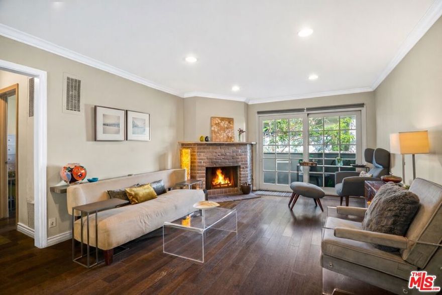 Metropolitan Urban Chic Oasis in Santa Monica! Exclusive controlled-access 14-unit courtyard enclave with lush landscaping. This top floor retreat with serene greenery views. Rich textured engineered wood floors across the entire unit with an expansive living room anchored by a classic brick gas fireplace. There is a seamless transition to the outdoors through elegant French doors to redone full balcony. Architectural depth is defined by elegant crown moldings and recessed lights in all rooms. Substantial full dining room that's capable of housing a full scale table, New grey wood sleek kitchen cabinetry and stainless steel appliances with quartz countertops with beautiful glass tile backsplashes and full granite sink. In-unit full size gas laundry provides ultimate in-home convenience and an updated dual- pane Milgard windows to optimize thermal insulation. Generously sized bedroom scaled to accommodate a dedicated workspace, Redone walk-in  shower room with integrated bench seating and double vanity. Secured gated parking with storage and Low homeowners dues.Premier location that balances residential tranquility w/immediate urban access. Perfectly positioned near World-Class Medical hubs St. John's and UCLA. Short distance to UCLA campus and public transportation and Close to Bristol Farms, Whole Foods, Trader Joes and Erewhon