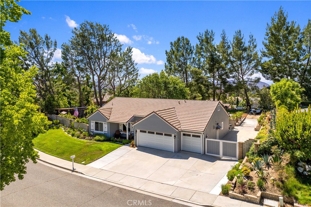 Welcome to this stunning single-story estate, nestled in the coveted "Bridal Path" community of Simi Valley. Greeted with a sweeping 1/2 acre corner lot with lush landscaping... This thoughtfully reimagined, light-filled home showcases gorgeous wood laminate floors that flow seamlessly throughout. The inviting living rm boasts an open floor plan with vaulted ceilings & a large formal dining room bursting with natural light. The custom gourmet kitchen is equipped with beautiful cabinets, gorgeous granite countertops, garden window, new energy-efficient stainless-steel appliances & large breakfast bar that opens to a separate family room w/ cozy brick fireplace & glass slider leading out to the resort-like back yard. The primary bedroom with vaulted ceilings offers a sanctuary with a spa-like ensuite bathroom with walk-in closet, new vanity, custom tile/fixtures, and huge walk-in shower. The secondary bedrooms are good size and are adjacent to the remodeled hallway bathroom, which includes stylish tile, new vanity & relaxing soaking tub. Step outside and enjoy the PARK-LIKE grounds within your private backyard including... a large, covered patio structures, mature foliage, Sparkling Heated POOL & Spa, separate herb garden w/ chicken coops, lovely mountain views & tons of rolling grass that is great for entertaining all your family and friends. With the new interior/exterior paint, recessed lighting, new dual paned windows, designer light fixtures/hardware throughout, individual laundry room and 3-car attached garage w/ gated RV parking... this is the one you have been waiting for!