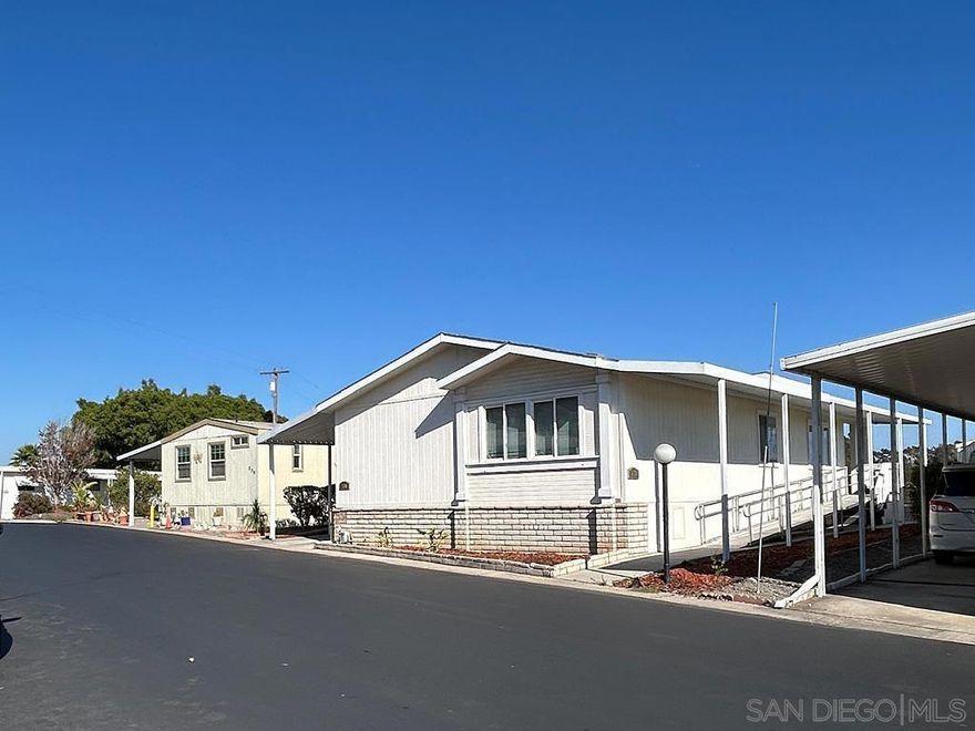 Welcome to this spacious, “Top of the Hill”, manufactured home in a clean, All Age community. This light & bright home, built in 2005 (not occupied until 2009), features an open-concept design, vaulted ceilings, skylights, and abundant windows. The open layout flows into the dining area and large kitchen with ample counter tops, cupboards and a pantry. Enjoy 180 degree views from the living room, kitchen and covered patio. A lovely ocean view and cool breezes keep the AC use way down in the hot months. Throughout the home, you’ll find high-end laminate wood flooring and thoughtful updates. The spacious primary suite offers a soaking tub, dual sinks and a ample linen closet. You’ll find full size closets in all of the bedrooms. Laundry with cabinetry includes the washer/dryer. HVAC with a new blower motor under warranty and a transferable 1 year service discount program (Home Depot) includes HVAC & plumbing. New sidewalk with retaining wall & railings, new porch deck sub-floor and recently re-leveled w/some piers replaced. Handicap ramp for easy accessibility for everyone, plus a 10×10 shed. Centrally located near downtown, beaches, shopping, dining, and community amenities, this home combines convenience, charm, and serene living in one great package!