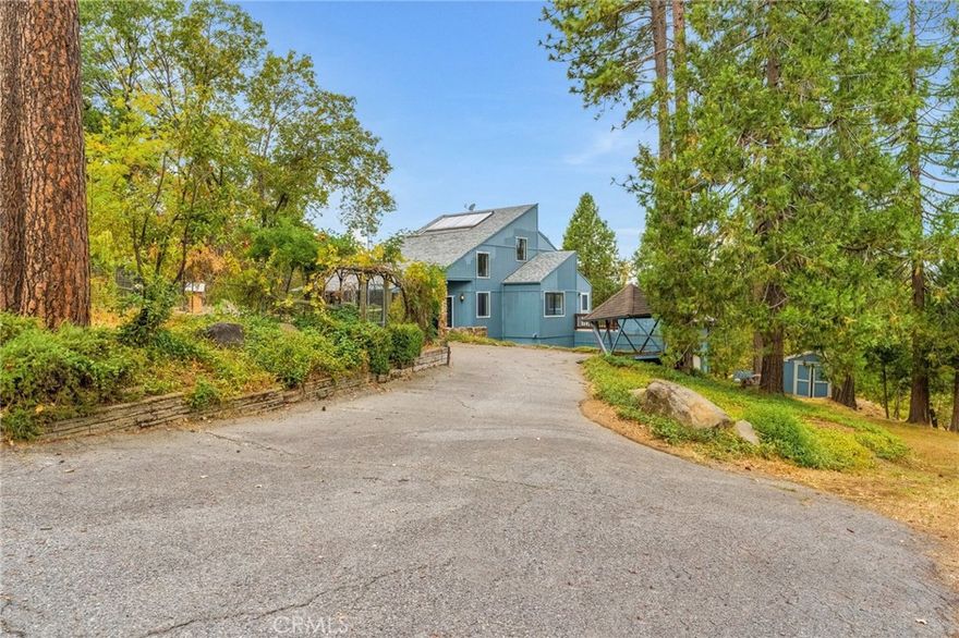 Welcome to 37068 Mudge Ranch Road, a unique tri-level mountain retreat you won't want to miss.

Enter into the grand living room featuring vaulted ceilings, abundant natural light, hardwood flooring, a cozy fireplace, a formal dining area, and access to the covered front patio. The kitchen offers granite countertops, newer appliances, a pantry, and deck access with views of the surrounding trees and landscape.

The main floor includes the primary suite with a spacious bathroom and large closet, plus an additional bedroom, guest bath, and storage.

Down the circular staircase, you'll find a private bedroom with its own bathroom, access to the backyard, a large utility closet, and the two-car garage. Upstairs, a fourth bedroom with a closet offers mountain views and completes this versatile layout.

This property combines privacy, comfort, and scenic beautya truly one-of-a-kind home. Schedule your showing today!