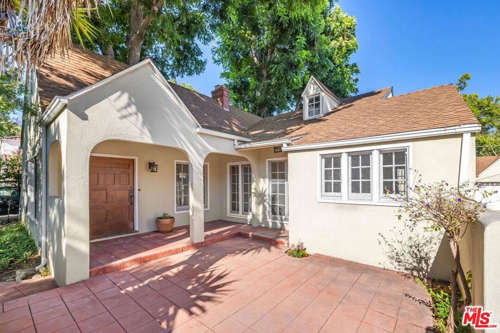 Your opportunity to lease a classic English Traditional in the highly sought-after Sunset Square neighborhood. Set behind hedges with a private front yard, this 4-bedroom, 2-bath home rests on an expansive lot enhanced by mature landscaping. The main level features a grand living room with French windows and a wood-beamed ceiling, a formal dining room with original tile, and a well-equipped kitchen that opens to a spacious courtyard (also accessible from the living room), perfect for indoor-outdoor living and entertaining. Three large bedrooms complete the main level, including one with direct access to a full bathroom. Upstairs, a fourth bedroom with its own bath offers the ideal space for a guest suite, office, or creative retreat. Additional highlights include a laundry room and a long gated driveway with parking for multiple cars. Situated just moments from the Sunset Strip, West Hollywood, the Melrose/Fairfax District, Hollywood Studios, Runyon Canyon, and with easy access to the 101, this home combines character, comfort, and location for the best of LA living. The detached Studio and Garage are not included in the lease.