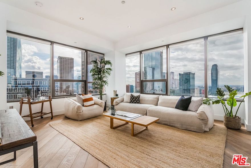 Set high above DTLA, this striking corner residence at 1100 Wilshire wraps the living space in glass, capturing sweeping 270 skyline and mountain views. Natural light pours in, pairing modern design with everyday functionality in one of Downtown's premier full-service towers. The updated kitchen offers refined cabinetry, granite counters, an oversized breakfast bar, and stainless-steel appliances. The spacious bath features dual vanities and contemporary finishes, while both bedrooms include custom-organized walk-in closets. Interior comforts include wide-plank hardwood floors and in-unit laundry. Practical perks: two reserved parking spaces on Level 5 and an optional same-floor storage unit available for an additional fee. Residents enjoy the 17th-floor Sky Deck with heated infinity pool, elevated spa, cabanas, BBQs, wet bar, and fire-pit lounge, plus a fitness center, screening room, business lounge, 24-hour attended lobby, and guest parking. Moments from LA Live, Crypto.com Arena, The Bloc, world-class dining, and the Financial District, this home delivers a polished urban lifestyle with unbeatable views. ***Some utilities are included.***