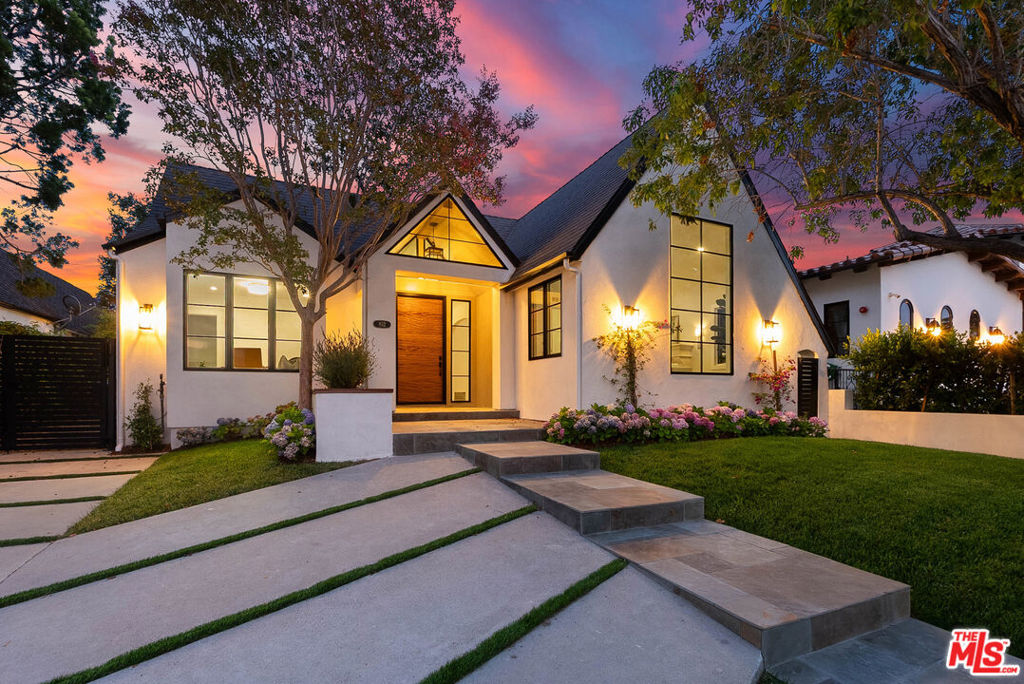Presenting a rare offering in one of Los Angeles' most coveted and architecturally rich neighborhoods. This Modern Tudor Revival in historic Brookside is a masterclass in refined design, offering the perfect fusion of old-world charm and contemporary living across a beautifully curated compound. A grand entryway welcomes you into this gorgeously reimagined family home, where soaring ceilings and oversized windows bathe every room in an abundance of natural light, creating a sense of scale and warmth throughout. The 4-bedroom main house features en-suite bathrooms in each bedroom, while the entire second floor is devoted to an exceptional primary suite complete with a steam shower, standalone tub, custom walk-in wardrobe, and a private balcony overlooking the beautifully landscaped backyard and pool. Downstairs the chef's kitchen anchors the home with a striking marble island and flows into the informal family room, complimented by a recessed Sonos sound system, seamlessly blending function and atmosphere. Separately, the formal living room boasts an original gas fireplace and soaring pitched ceilings, offering a perfect space for entertaining friends and family. Step into the backyard and discover a private resort-like oasis where every detail invites a sense of relaxation and a chance to unwind. This home's luxurious amenities extend to its large swimming pool featuring an integrated spa and cascading waterfall from an elevated deck, complete with a swinging bench suspended from a mature tree. Whether hosting a lively gathering or enjoying peaceful solitude, this outdoor space delivers on every level. Nestled in the serene back yard is a fully permitted ADU, ideal for guests, extended family, a home office or income generation. The ADU is equipped with a full kitchen, bathroom, and bright living space thanks to multiple skylights, reflecting the same exceptional attention to detail seen in the main house. Adjacent to Hancock Park, moments away from Larchmont Village and The Grove, and a short commute to Hollywood, West Hollywood and Beverly Hills, this home's location is truly unbeatable. Whether you're headed west to Santa Monica or east to DTLA, this home places you at the nexus of everything Los Angeles has to offer without compromising privacy or charm.