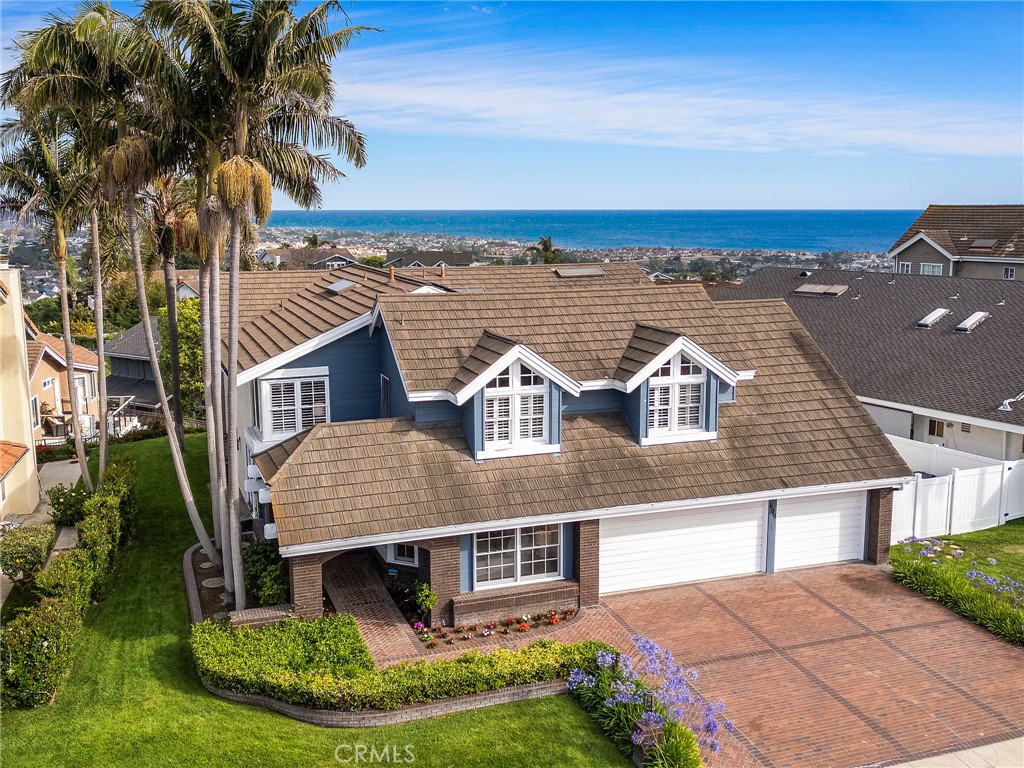 Elevated high in the hills of the prestigious Coast District, this home captures sweeping ocean views that embody the allure of San Clemente’s coastal lifestyle. Set on a private, wide, and flat cul-de-sac surrounded by custom estates, the location is truly exceptional. Crisp curb appeal is evident with newer exterior paint, a wide brick driveway, a sought-after three-car garage, and mature palm trees that beautifully frame the home. Inside, a spacious living room welcomes you with soaring beamed ceilings, a dramatic crystal chandelier, and a wall of French doors that flood the space with natural light. A main floor bedroom offers the perfect setup for guests or extended stays. Down the hall, the family room centers around a cozy gas fireplace and opens to a casual breakfast area—both ideal for everyday living. The kitchen showcases rich wood cabinetry, a massive granite island and counters, 6-burner Viking pro range with oversized vent hood, Sub-Zero fridge/freezer, large pantry, and built-in desk nook. Large windows in the kitchen and breakfast area bring in ocean views and open to the outdoor patio, finished with custom pavers and offering even more ocean views. The formal dining room connects seamlessly to both the kitchen and living room for easy entertaining, while a bright sunroom offers a tranquil retreat. Rounding out the main floor is a large study with an upgraded bathroom with an ADA compliant shower, plus an additional powder room. Upstairs, wide hallways lead to three oversized bedrooms and a spacious bonus room. The primary suite enjoys breathtaking ocean, and mountain views. Vaulted ceilings with exposed beams, a private fireplace, and an enclosed sunroom make it a true sanctuary. A large walk-in closet and upgraded bathroom complete the suite—featuring a marble walk-in shower with dual rainfall heads and frameless glass, and a freestanding clawfoot tub. Down the hall, two generous bedrooms share an upgraded Jack and Jill bath, making this layout ideal. At the end of the hall, the large bonus room features beamed ceilings and a full wet bar, offering the potential for added bedrooms or keeping it as a game room. Other Values include: 41 fully paid solar panels, EV charging, and a whole-house water softener system. A quick drive to the historic downtown, new restaurants, the 2.5-mile beach trail, SC Pier, and amazing beaches. For those in pursuit of an ideally located home with major relief, coastline, and ocean views—this is it.