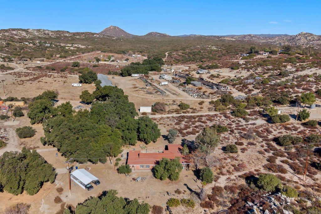 ENDLESS OPPORTUNITES NESTLED UPON 6.25 ACRES! This 4 bedroom, 2 bath cosmetic fixer is nestled within 6.25 acres of breathtaking views, it presents a unique opportunity for those with a vision of creating their dream home. This property needs a little love but the land is incredible. Mature oaks and meadow areas. Property is on well and propane. Lots of parking, extra storage, chicken coop, and so much more. Located in a peaceful and private setting, this property offers the perfect canvas for a personalized oasis. You can restore the existing structure or design your own dream home from scratch. Plenty of room on property for an ADU as well. Attached garage was converted into storage with workshop. The 0.25 Acre Vacant lot next door is also for sale MLS#NDP2410455! Quick drive to top rated schools (Campo Elementary School and Mountain Empire High School), fire station, Morena Lake, Cleveland National Park, Railroad Museum & amenities. Grab your imagination and don’t miss out on this excellent opportunity!
