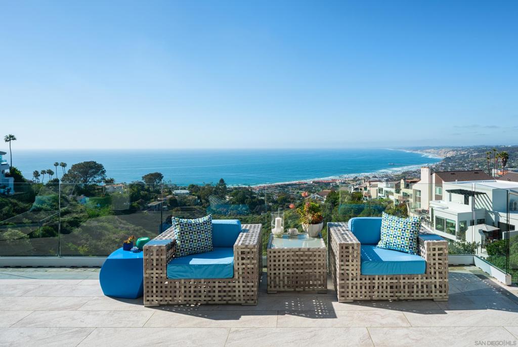 Nestled behind beautifully landscaped hedging and private gates, this impeccably remodeled estate boasts one of the best VIEWS in all of La Jolla. Nearly every space in this 7,383 sqft home enjoys panoramic ocean, North coast, and night light views stretching from La Jolla Village to Dana Point. Vaulted ceilings and floor to ceiling walls of glass illuminate the sprawling open concept living spaces, flood the home with natural light, and accentuate the phenomenal views. Extensively remodeled in 2018, the home features a sprawling main level, including the primary retreat complete with new Versailles Oak flooring, solid marble fireplace, and a spa-like primary bath featuring custom Rutt cabinetry, marble finishes, his and hers walk in closets, and breathtaking ocean views. Designed to embrace indoor/outdoor living, the main level living spaces flow seamlessly into the expansive outdoor patio, a perfect space to lounge, dine, or entertain while enjoying the views. The chef's kitchen features a full Miele appliance suite, double dishwashers, custom steel stove hood, Subzero fridge, freezer, and cooling drawers, honey quartzite countertops, LED lit quartzite backsplash, walk in pantry, custom Rutt cabinetry, designer lighting, and an indoor-outdoor breakfast bar. By way of either the elegant limestone spiral staircase or the elevator, you arrive at the second level of this home, which boasts 4 fully en-suite bedrooms all with panoramic ocean views and access to the outdoor space, a movie theatre with new projector and system, wet bar, lounge, billiards room, kitchenette, full laundry room, and massive office highlighted by walls of retractable glass opening to the wonderfully landscaped outdoor space. Other features include a BOSE whole home sound system, owned Solar System (and grandfathered in SDGE Net Metering), new LED light fixtures throughout, new hot water heaters, custom garage doors and storage, stunning living walls designed by TrueVert, and perhaps most importantly, PLENTIFUL STREET PARKING adjacent to the home. This is truly a rare opportunity to enjoy forever unobstructed ocean and North coast views from a masterfully renovated La Jolla estate.