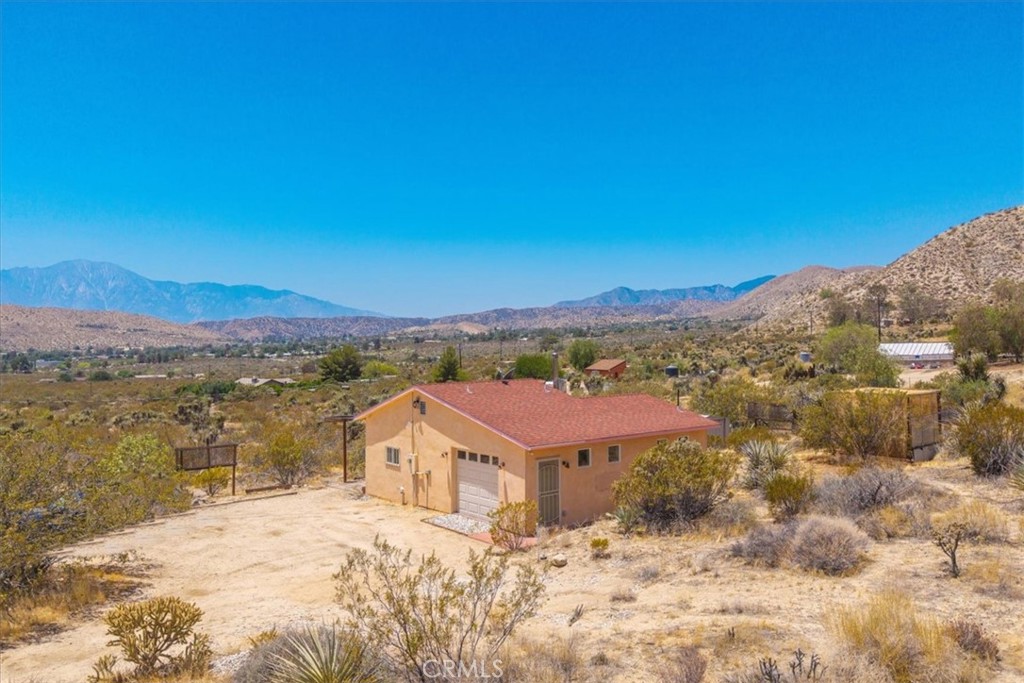 Discover rustic elegance and desert tranquility in this beautifully remodeled and permitted 1-bedroom, 1-bathroom home, originally a classic cabin, now transformed into a stylish retreat. Situated on a little over 7 acres (4.53 acres + additional 2.5-acre parcel), this property offers space, privacy, and unmatched views of the Morongo Valley landscape. Inside, the home features thoughtful upgrades that blend modern comfort with cabin charm with an open-concept layout, including a roll up door that brings the outside in! The main part of the home has stained concrete floors to keep it cool in the summer, and the kitchen has a wood burning stove for extra heat to create a warm and inviting atmosphere. There's also mini split for heat and a/c for even more climate control. The spacious bedroom opens to wide desert skies and serene mornings with access to the south facing patio. Step outside to your private outdoor living area, designed for entertaining or peaceful evenings under the stars. Relax in the hot tub while taking in views of the surrounding hills and open desert—perfect for stargazing or soaking after a long day. Whether you're looking for a weekend escape, full-time residence, or unique investment property, this one-of-a-kind desert gem offers a rare combination of character, land, and lifestyle. Just minutes from Joshua Tree, Pioneertown, and the Big Morongo Canyon Preserve, and a short drive "down the hill" to Palm Springs and the low desert!