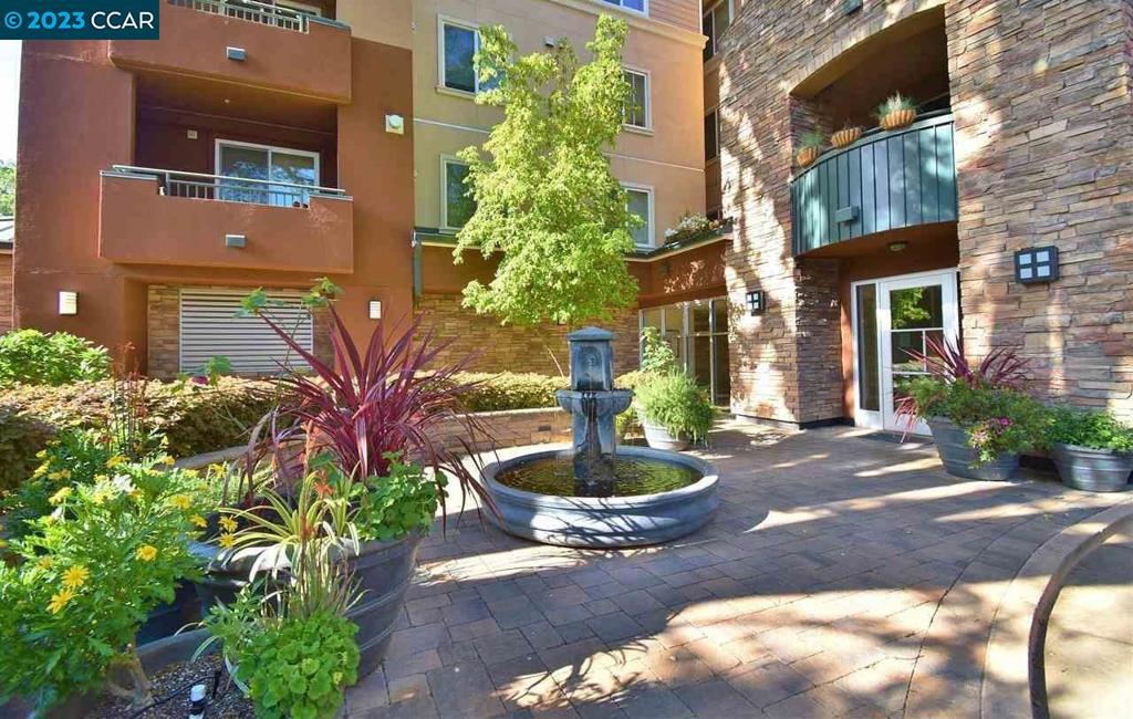 Stunning luxury 2 bed, 2bath condo, end-unit close to downtown Walnut Creek! Beautifully finished with high ceilings, New Paint, New Carpet & modern amenities. Enjoy the gas fireplace in living room with granite surround. Kitchen has granite countertops, stainless appliances including gas range (new in 2022), Newer Refrigerator and is open to dining & living rooms. Spacious primary suite has walk-in closet. Primary bath has double sink vanity, shower over tub. Laundry in unit, stacked system replaced in 2022. Private balcony with tree views. Gated garage parking for 2 cars. Secure building with elevator, work out room and bike storage. Private locked gate for homeowners to access the Iron Horse Trail. Bus stop adjacent to driveway for free BART & downtown bus. Great schools!