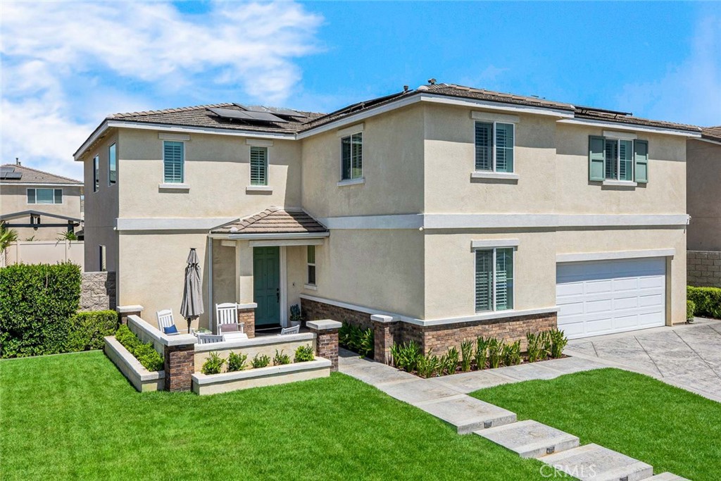 Welcome to this stunning two-story home in the desirable Turnleaf community of Jurupa Valley. Built in 2019, this spacious residence offers 5 bedrooms, 3 full bathrooms, a large bonus room, and a 3-car garage across 3,386 sq. ft. of living space. Step inside to an open-concept floor plan filled with natural light. The extra-large kitchen is a true showpiece with extended white cabinetry, quartz countertops, updated backsplash, stainless steel appliances, a walk-in pantry, double beverage refrigerators, glass-front cabinets, LED accent lighting, and a massive center island perfect for entertaining. The kitchen seamlessly flows into the family room and dining area. A convenient bedroom and full bathroom are located downstairs, featuring a standard closet, along with a coat closet and storage under the staircase. Upstairs, the primary suite features a walk-in closet, dual sink vanity, separate soaking tub, and shower. The bonus room offers flexible space for a media area, playroom, or home office. The laundry room is upgraded with a sink and custom cabinetry. Three spacious secondary bedrooms are also upstairs — each with its own walk-in closet, and one bedroom boasting two walk-in closets. This home is loaded with upgrades including: solar panels, luxury vinyl plank flooring throughout, custom stair skirt and glass stair rail, upgraded baseboards and door trim, soft-close drawers and pull-out shelves, plantation shutters on every window, landing cabinetry with quartz counters, and fresh paint throughout. The finished garage includes built-in cabinetry, numerous overhead storage racks, and a Tesla charger. Outdoor living is just as impressive with a stamped concrete driveway and courtyard, extended covered back patio with fans and lighting, and beautifully finished front entry steps. Located on a cul-de-sac with easy access to the 15, 60, and 91 freeways, this home combines style, comfort, and convenience.
