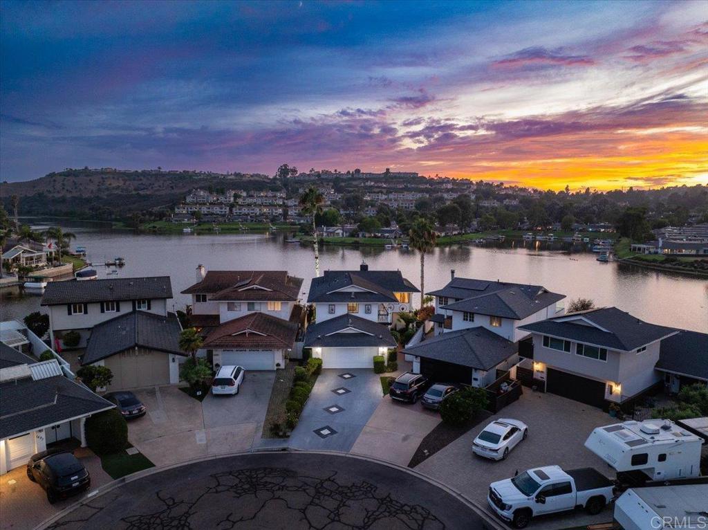 Lakefront Home w/Spectacular Views !!! Don't miss this once in a lifetime opportunity to own this 4 bedroom/2.5 bath detached home showcasing the most breathtaking & incredible water views in all of Lake San Marcos. The location of this resort style home (with its own dock & direct access to the lake) epitomizes the lifestyle & serenity everyone dreams of. The spacious 2,536 sq. ft. floor plan features two large living areas. One showcases floor-to-ceiling windows with stunning panoramic lake views, giving the impression that you're floating on the lake itself. The second living area invites you to saunter through the sliding glass doors that leads to a generous outdoor patio—perfect for entertaining, enjoying cool breezes, and taking in the incredible scenery. The main level also includes an inviting kitchen that opens to the dining area (with more amazing views) plus a versatile flex room with closet—ideal as a bedroom, office, or bonus space. Upstairs you'll find two guest bedrooms (each with its own private balcony) a large guest bathroom & the primary suite. The primary features an en-suite bath and an expansive deck that captures the VERY BEST VIEWS the lake has to offer—a true showstopper. Whether you're seeking a vacation home or a permanent residence, this property offers the best of both worlds. Just a short walk to golf, dining, and the many amenities Lake San Marcos is known for. FEATURES INCLUDE: *Spectacular & unobstructed views of Lake San Marcos *4 bedroom 2.5 bath (2,536 sqft) detached home *Direct lake access w/optional private dock *2 car garage w/extra long driveway *Incredible value ~ remodel to your own liking and gain instant equity *Expansive balconies & multiple lake viewing areas *Serene location on the end of a cul-de-sac (no traffic) *Access to the mall 3 swimming pool *Indoor laundry area *Premier school district *Enjoy wildlife, sunsets, boating (boat parades), summer concerts, paddle boarding, kayaking, fishing ~ All from the privacy of your personal lakefront resort.