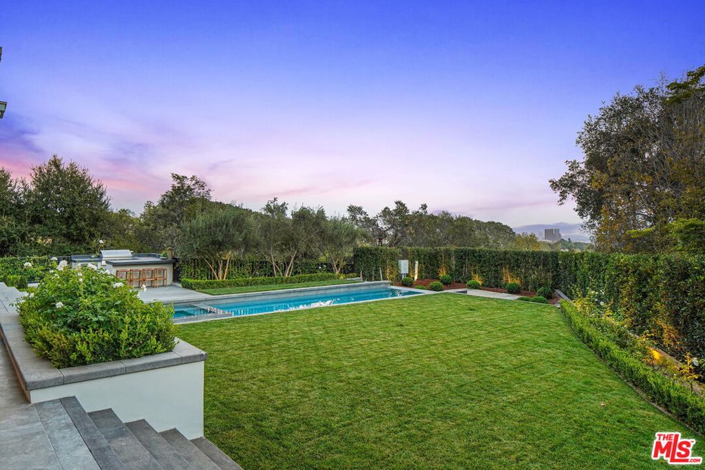 A rare opportunity on one of the most exclusive streets in Brentwood Park, this newly constructed eight-bedroom masterpiece blends opulent luxury with California's coveted indoor-outdoor lifestyle. From renowned architect Ken Ungar and Los Angeles builder Heltzer Development Group lnc, comes this immaculate estate consisting of 12,800 square feet of meticulously crafted living space using the finest materials available. The main level offers formal entertainment areas equipped with elegant bars, living room, dining room, and spacious family room accentuated by white oak hardwood floors, coffered and beamed ceilings, stunning fixtures, fireplaces, and windows that allow an abundance of natural light. The inspiring chef's kitchen features stainless steel Wolf and Sub Zero appliances, built-in Miele coffee machine and beautiful stone countertops and backsplash. More than a bedroom, the sprawling primary suite is in a class of its own, with a private wraparound balcony, double custom walk-in closets and sitting room with fireplace, along with a marble-clad primary bath with double vanity, soaking tub and standing shower centerpiece. The lower level offers a state-of-the-art home theater, personal gym, temperature controlled wine room, and games room with a bar. An expansive backyard offers rare and spectacular city views and immersive outdoor living, with a sparkling pool with spa, built-in kitchen, dining area, and heated lounge with a fireplace. This Brentwood dream home offers every luxury one could imagine in an unparalleled location.