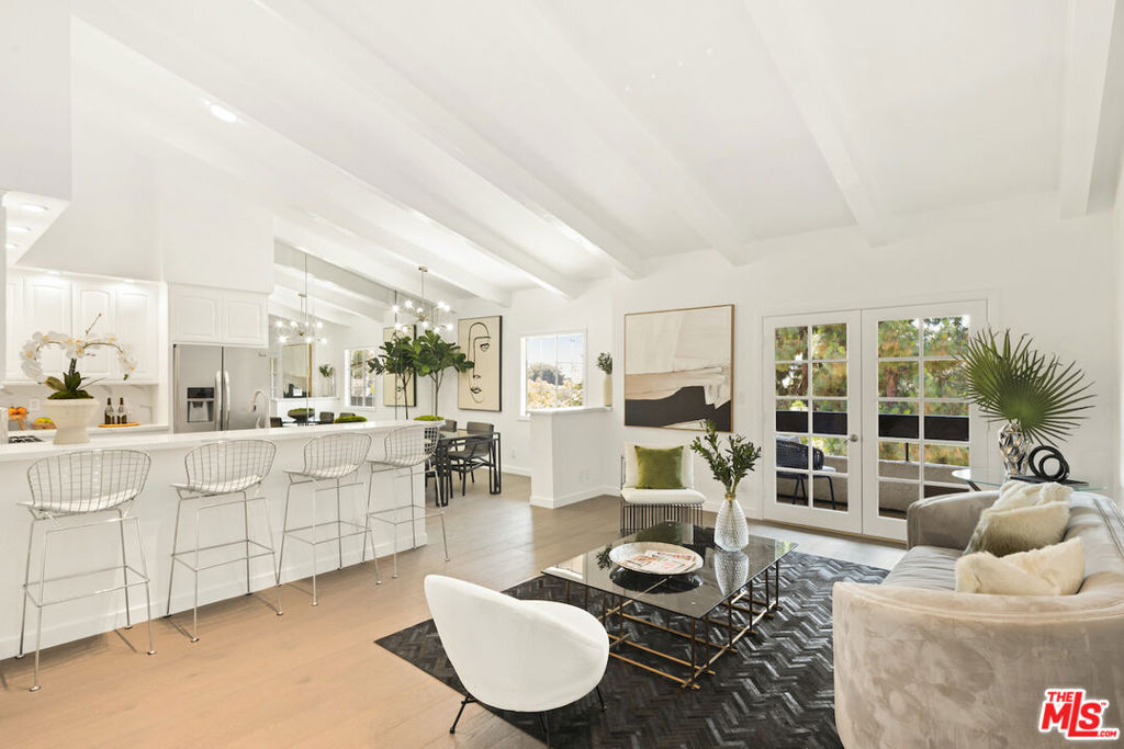 With sweeping views of the enchanting Hollywood Hills, this top-floor 2BD/2BA condo is a rare retreat where golden-hour sunsets and treetop vistas set the stage for everyday canyon magic. Inside, soaring vaulted ceilings and southwest light create an airy, expansive feel. The balcony off the living room with french doors faces westward to enjoy daily sunsets. Stylishly remodeled throughout, the home features wide-plank hardwood floors, designer lighting, and a sleek open-concept kitchen with stainless steel appliances against a backdrop of glamorous Milan white quartz counters with a continuous backsplash -- an ultra-elegant yet highly functional design. The primary suite offers spa-like comfort with a deep soaking tub, oversized shower, bidet and refined finishes. A whimsical upstairs loft once curated as a Moroccan-style lounge adds an unexpected escape and can be easily reimagined as a meditation area, reading nook, or nap space. Life at the Cahuenga Hills Tennis Club is resort-style and serene. This guard-gated community spans 15 lush acres and offers three tennis courts, two swimming pools and spas, a modernized gym with top-tier equipment, saunas, clubhouses, sun decks, private hiking trails around Lake Hollywood, dog parks, and plentiful guest parking. Perfectly positioned just minutes from the Hollywood Bowl, Studio City, Los Feliz and LA's most iconic shops and restaurants, this home is as connected as it is private. Added conveniences include a washer dryer in-unit and newer HVAC. The HOA coverage includes earthquake insurance, water, cable TV, and internet. Come see this beauty and experience Hollywood Hills living.