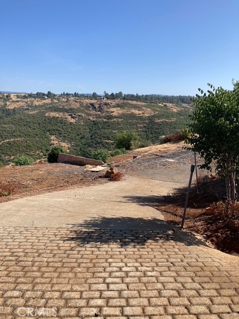 RARE .9-ACRE HOMESITE WITH STUNNING CANYON VIEWS IN LOWER PARADISE! Perched above the valley fog, this hard-to-find .9-acre parcel offers sweeping canyon vistas and a tranquil setting—ideal for building your dream home. Located on desirable Russel Drive, this property combines natural beauty with commuter convenience, offering quick access to the Skyway and just minutes from Chico and the surrounding valley. The lot previously hosted a 2-bedroom, 2-bath home, and the paved driveway access remains in place, streamlining your rebuild plans. Whether you’re looking to design a peaceful retreat or an investment in Paradise’s ongoing renewal, this lot is a rare opportunity. Come explore the potential and be a part of the revitalization of Paradise!