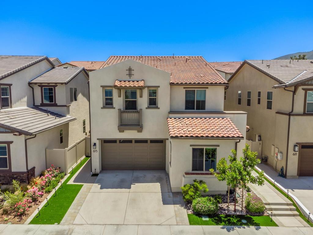 Welcome to modern luxury in one of San Marcos’ most sought-after newer gated communities—Mission Circle. This stunning 3,760 sq. ft. home, built in 2022, offers a rare combination of high-end finishes, practical living space, and exceptional flexibility, all within a meticulously maintained neighborhood that boasts resort-style amenities. One of the standout features of this home is the attached Next Gen suite, providing a unique multi-generational living solution rarely found in the area. With a private entrance, full kitchen, full-size washer and dryer, and a zoned HVAC system, this suite is a completely independent living space, perfect for extended family, guests, or even as an income-producing rental. This level of flexibility is a rare find in the community, particularly when compared to smaller models. The main residence features a spacious, open-concept floor plan with soaring 10-foot ceilings and an abundance of natural light. Luxury vinyl plank flooring flows seamlessly throughout the main living areas, which include a gourmet kitchen with quartz countertops, stainless steel appliances, a large center island, and a walk-in butler’s pantry. An enclosed California room adds an additional 153 sq. ft. of versatile living space—ideal for a home office, fitness area, or a cozy lounge. The expansive primary suite is a serene retreat, featuring dual walk-in closets, a soaking tub, a walk-in shower, and dual vanities. The additional bedrooms and bathrooms are equally well-appointed, ensuring comfort and convenience for families of all sizes. Energy-efficient upgrades include zoned HVAC systems, tankless water heaters for both the main home and ADU, solar panels, smart-home features, and high-speed fiber internet. Custom window shades add both comfort and style throughout the home. As a resident of Mission Circle, you’ll enjoy access to a resort-style pool and spa, a dog park, tot lot, picnic areas, and more—all within a secure, gated environment. The location is second to none, just minutes from shopping, dining, Costco, hospitals, and major freeways (I-78 and I-15). Families will appreciate the proximity to top-rated schools such as Discovery Elementary, San Marcos High School, CSUSM, and the prestigious Pacific Ridge School, all within a short distance. Don’t miss out on the opportunity to own one of the most versatile and upgraded homes in Mission Circle, located in one of San Marcos’ most desirable communities. This rare offering combines luxury, flexibility, and an unbeatable location—perfect for today’s modern lifestyle.