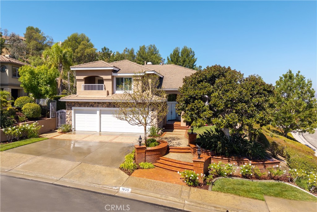 Step into a world of elegance and comfort at this stunning 5-bedroom, 4.5-bathroom pool home with partial views, perfectly located in the heart of Anaheim Hills. From the moment you enter through the double doors into the grand foyer beneath a sparkling chandelier, this home makes a lasting impression.
To your right, the formal living room sets the tone with rich wood floors that flow seamlessly into the dining room, where French doors invite you to step outside and enjoy the beauty of the backyard. Wood shutters, crown moldings, and timeless design details add warmth and sophistication throughout.
At the heart of the home, the expansive kitchen is designed for both daily living and entertaining. Granite countertops, stainless steel appliances, built-in refrigerator, 5-burner cooktop, and walk-in pantry provide everything a chef could want. The oversized bay window floods the space with natural light while overlooking the sparkling pool. Just beyond, the inviting family room with fireplace offers the perfect place to gather, with sliding glass doors leading to the backyard oasis.
A main floor bedroom with en-suite bath offers flexibility for guests or a home office, while a separate powder room adds convenience.
Upstairs, the primary suite is a private retreat all its own. Double doors open to a spacious sanctuary with fireplace, sitting area, infrared sauna, dual walk-in closets, and spa-inspired bath with dual sinks, walk-in shower, and jetted tub. Three additional bedrooms complete the upper level—two connected by a Jack & Jill bath, one with a balcony to enjoy evening breezes, and another with a large walk-in closet and mirrored wardrobe doors.
The backyard is truly the soul of this home—a resort-style haven where every detail is designed for entertaining and relaxation. Multiple Alumawood patio covers with ceiling fans and lighting create the perfect setting for outdoor dining. A built-in BBQ makes weekend gatherings effortless, while the pebble tek and salt water pool and spa invite endless hours of fun and tranquility.
Additional features include updated stair railings, plantation shutters throughout, water softener and purifier, whole-house fan, crown molding and so much more.
This home is more than a place to live—it’s a lifestyle. With its perfect blend of luxury and warmth, it’s ready to welcome you home.