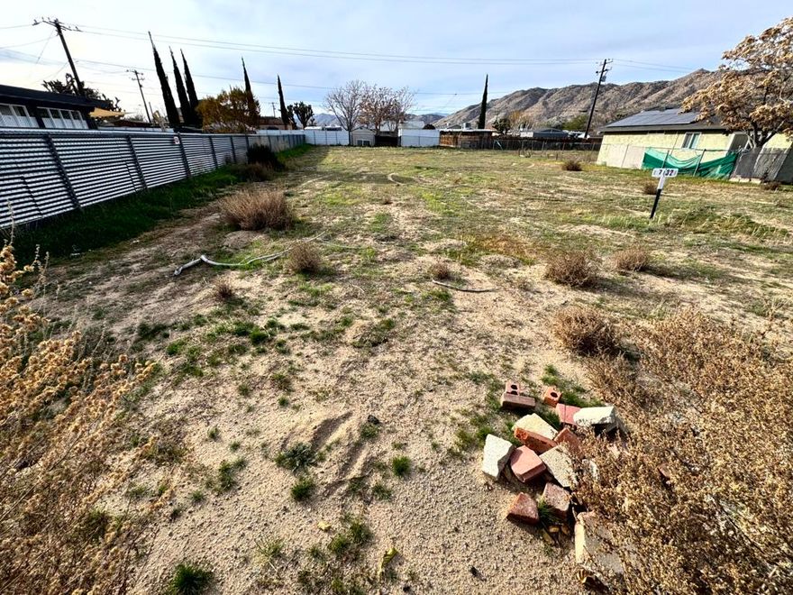 Prime Level Lot in the Heart of Yucca Valley - Ready for Your Vision! **PRICED FOR IMMEDIATE SALE**Description: Located in the desirable Downtown North area, this +/-10,721 sq. ft. flat and usable parcel offers a rare opportunity to build in an established neighborhood. Situated on a paved, publicly maintained street, this lot is perfectly positioned just minutes from local shopping, dining, and the gateway to Joshua Tree National Park.Utilities are conveniently located at or near the street, including public water(ALREADY HAS WATER METER) and electricity (POWER POLE ON SITE). **ADDRESS ALREADY ASSIGNED. THE ONLY THING MISSING IS CONNECTING THE POWER & SEWER OR SEPTIC.The property is within the highly-regarded Morongo Unified School District and is a short distance to Yucca Valley High School. With R-S-5 zoning, this land is ideal for a custom single-family residence. Enjoy stunning desert mountain views and the convenience of being centrally located while maintaining a sense of space. Buyer to verify all utility connection fees, zoning requirements, and sewer assessment status with the Town of Yucca Valley and Hi-Desert Water District. Don't miss one of the few remaining infill lots in this prime location!