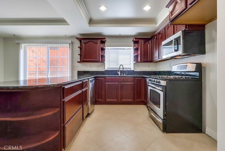 Discover the perfect blend of comfort, style, and convenience in this spacious 2-bedroom unit, ideally located in the heart of the Mid-Wilshire Financial District. Flooded with natural light from multiple windows and two balconies, this well-maintained condo offers an open floor plan with gleaming cherry wood floors, laminate and stone, crown molding, and a cozy fireplace. The dining area opens to a balcony with beautiful views, while the wide hallway leads to a versatile den/office, or third bedroom, a full guest bath, and in-unit laundry with side-by-side washer and dryer hook-ups. The primary suite features a large en-suite bath with jetted tub, while the den’s sliding doors open to a second private balcony—perfect for fresh air and relaxation. The home also boasts abundant storage, granite countertops, recessed lighting, and central air/heat. Set in a boutique 35-unit building with solid construction, residents enjoy modern amenities including solar panels, EV charging stations, a recreation room, gym, secure access, gated garage parking, and guest parking. All this just one block from the Wilshire corridor’s dining, shops, the Metro, the LINE Hotel, and more. A rare opportunity to own a serene retreat in a vibrant urban setting!