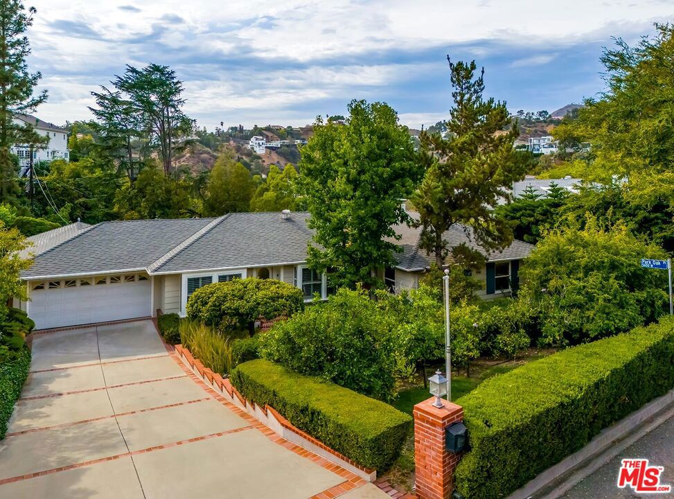 A Rare Opportunity in The Oaks of Los Feliz. Welcome to 2541 Oak Park Drive, a charming single-story traditional home located in the highly desirable neighborhood of Los Feliz Oaks. This property presents a rare opportunity, as it is being offered on the market for the first time in 43 years. Situated on a sprawling, 16,000+-square-foot flat lot that offers impressive views. The generous size of the lot provides ample space for outdoor living and future enhancements such as an ADU, pool, cabana, and more. This beautiful traditional home is brimming with potential for those who have vision. With thoughtful updates or renovations, it can be transformed into an exceptional property. Stepping inside, you will find an inviting floor plan that features a spacious living room and a family room adorned with wood-beamed ceilings. A wall of glass reveals breathtaking Hollywood Hills views, seamlessly blending the indoor and outdoor spaces. The formal dining room has abundant natural light and connects to the country-style kitchen. For casual everyday dining, there is an area that enjoys lovely views of the hills and mountains. There are three bedrooms on the main level and two and a half bathrooms. The primary bedroom on the lower level is spacious with ample walk-in closet space, a fireplace, a private patio, and an ensuite tiled bath. Outdoor living at its best with a large deck for entertaining, and an expansive yard to create your dream sanctuary. Mature landscaping surrounds the property, providing privacy and a serene setting in one of Los Angeles' most sought-after neighborhoods. The home also includes a generously sized laundry area with plenty of storage and direct access from the garage. Additionally, there is a substantial, usable basement that provides even more space for storage or future possibilities.
